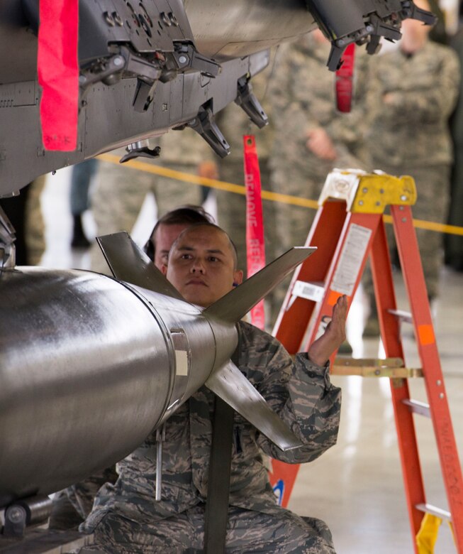 Staff Sgt. Ryan Reyes, 389th Aircraft Maintenance Unit weapons load crew chief, helps position a training munition to be secured to his team's F-15E Strike Eagle during a load event Oct. 14, 2016, at Mountain Home Air Force Base, Idaho. The event highlights the skills of the load crew members and gives spectators a rare glimpse of what goes into loading an F-15E.