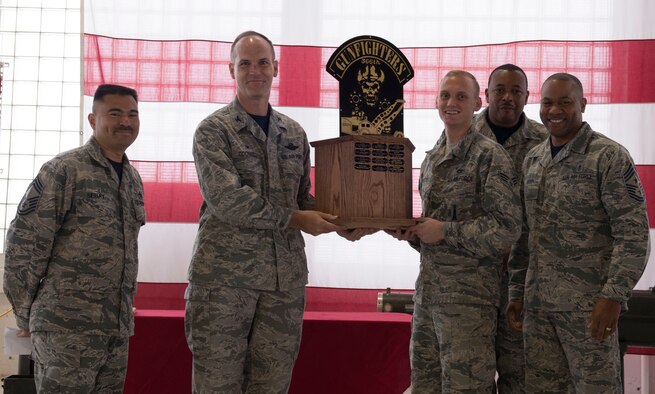 366th Fighter Wing commander Col. Jefferson O'Donnell presents Senior Airman Cameron Platt, 366th Equipment Maintenance Squadron armament cast member, with the 1st place trophy for the munitions lift truck maneuverability competition Oct. 14, 2016, at Mountain Home Air Force Base, Idaho. The course included weaving between cones, dropping a skeleton into a bucket and smashing pumpkins. (U.S. Air Force photo by Airman Jeremy D. Wolff/Released)