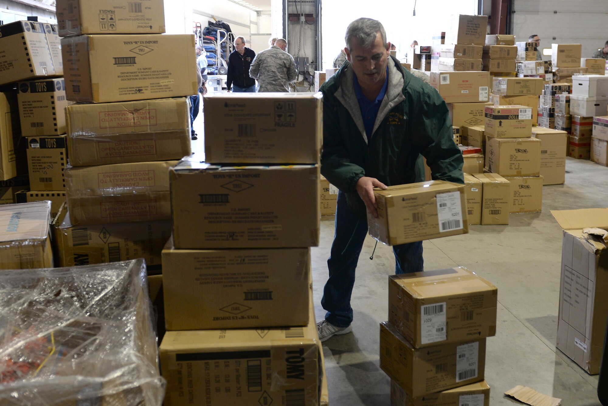 Jon Jerome, president of H.E.R.O.E.S. Care hepls stack boxes of toys into the Civil Engineering Squadron Compound, Scott Air Force Base, Ill. Oct. 13, 2016. H.E.R.O.E.S. Care is an organization that serves military members and their families by providing material and financial aid and other assistance and services to all branches of the military, guard and reserve forces. (U.S. Air Force Photo by Senior Airman Megan Friedl)
