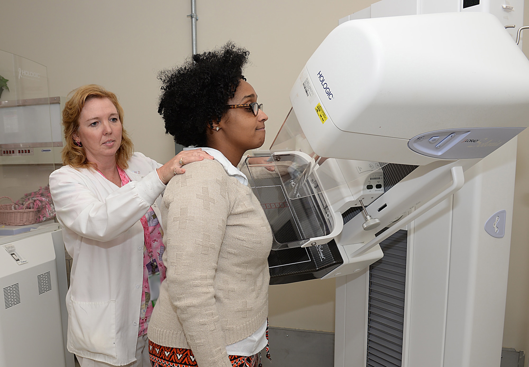 Wendy Elvis, 633rd Surgical Operations Squadron lead mammography technician, demonstrates the use of a mammogram machine with Melissa McRae, 633rd Surgical Operations Squadron command secretary, at Joint Base Langley-Eustis, Va., Oct. 17, 2016. Mammograms are recommended for women over the age of 40 and those whose family has a history of breast cancer. (U.S. Air Force photo by Staff Sgt. Teresa J. Cleveland)
