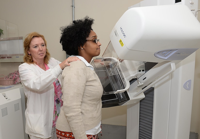 Wendy Elvis, 633rd Surgical Operations Squadron lead mammography technician, demonstrates the use of a mammogram machine with Melissa McRae, 633rd Surgical Operations Squadron command secretary, at Joint Base Langley-Eustis, Va., Oct. 17, 2016. Mammograms are recommended for women over the age of 40 and those whose family has a history of breast cancer. (U.S. Air Force photo by Staff Sgt. Teresa J. Cleveland)
