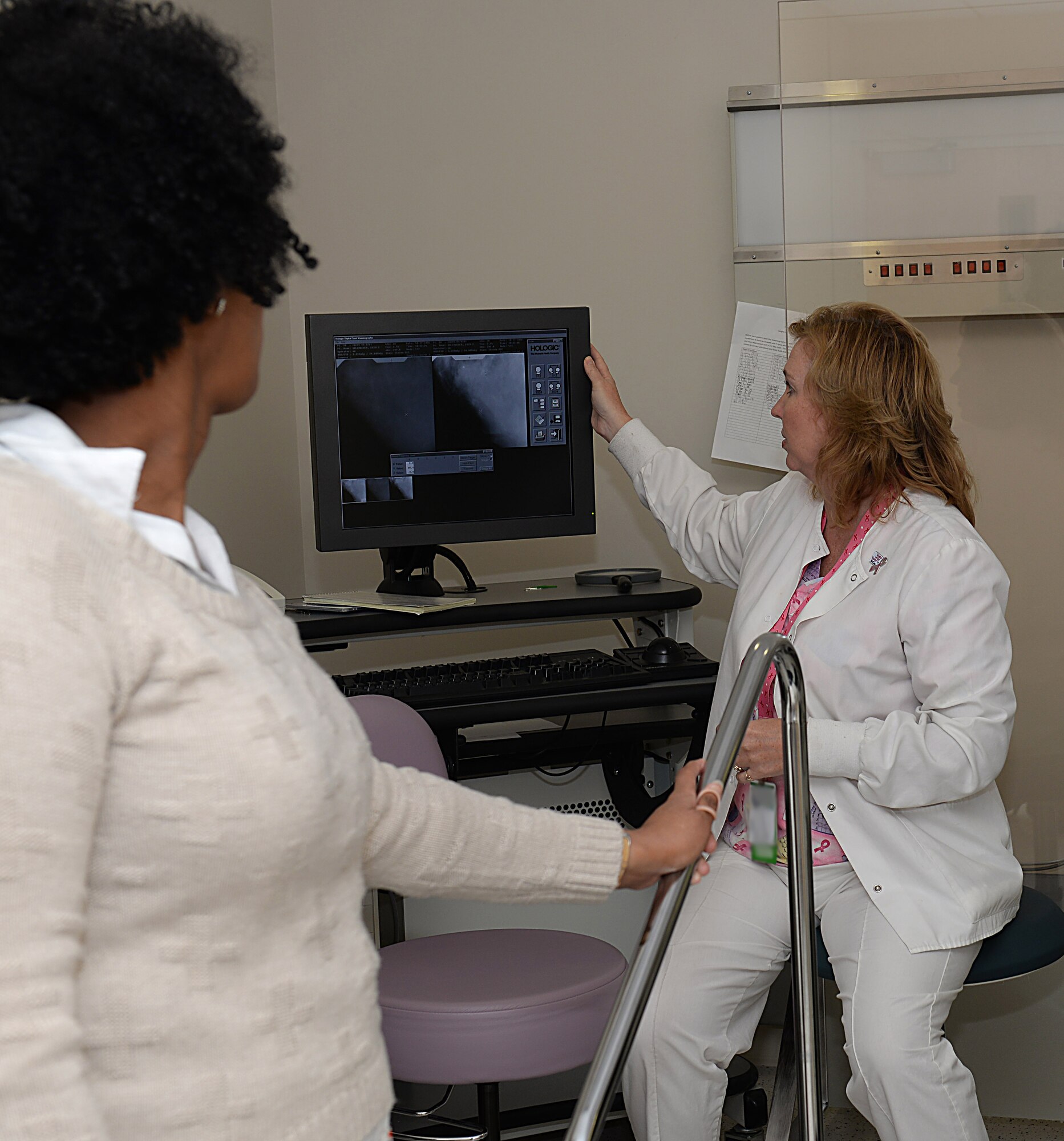 Wendy Elvis, 633rd Surgical Operations Squadron lead mammography technician, shows what is seen during a breast biopsy to Melissa McRae, 633rd Surgical Operations Squadron command secretary, at Joint Base Langley-Eustis, Va., Oct. 17, 2016. JBLE’s Women’s Health Clinics and Mammography Departments recommend women avoid putting off mammograms and regular women’s health appointments because early detection is the best way to increase a patient’s survival rate if they are diagnosed with breast cancer. (U.S. Air Force photo by Staff Sgt. Teresa J. Cleveland)