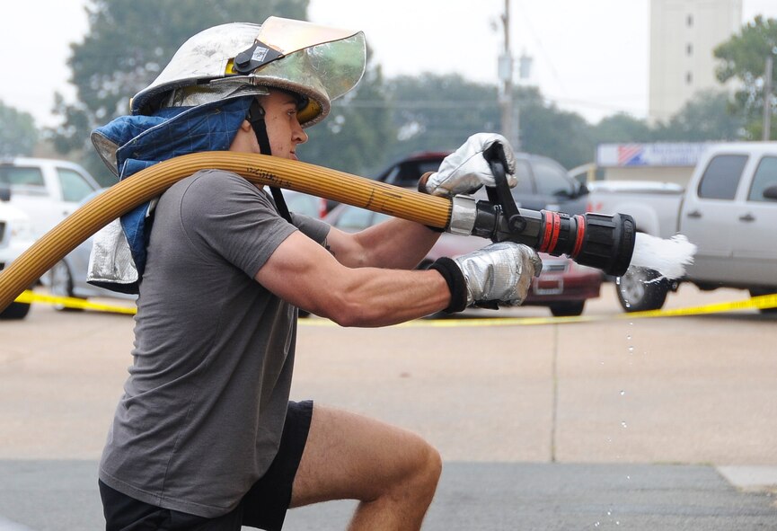 An Airman participates in the hose pull challenge during the fire muster competition at Barksdale Air Force Base, La., Oct 13, 2016. After reaching the finish line, the Airman charged the hose to signal their team finished the course. (U.S. Air Force photo/Airman Alexis C. Schultz)