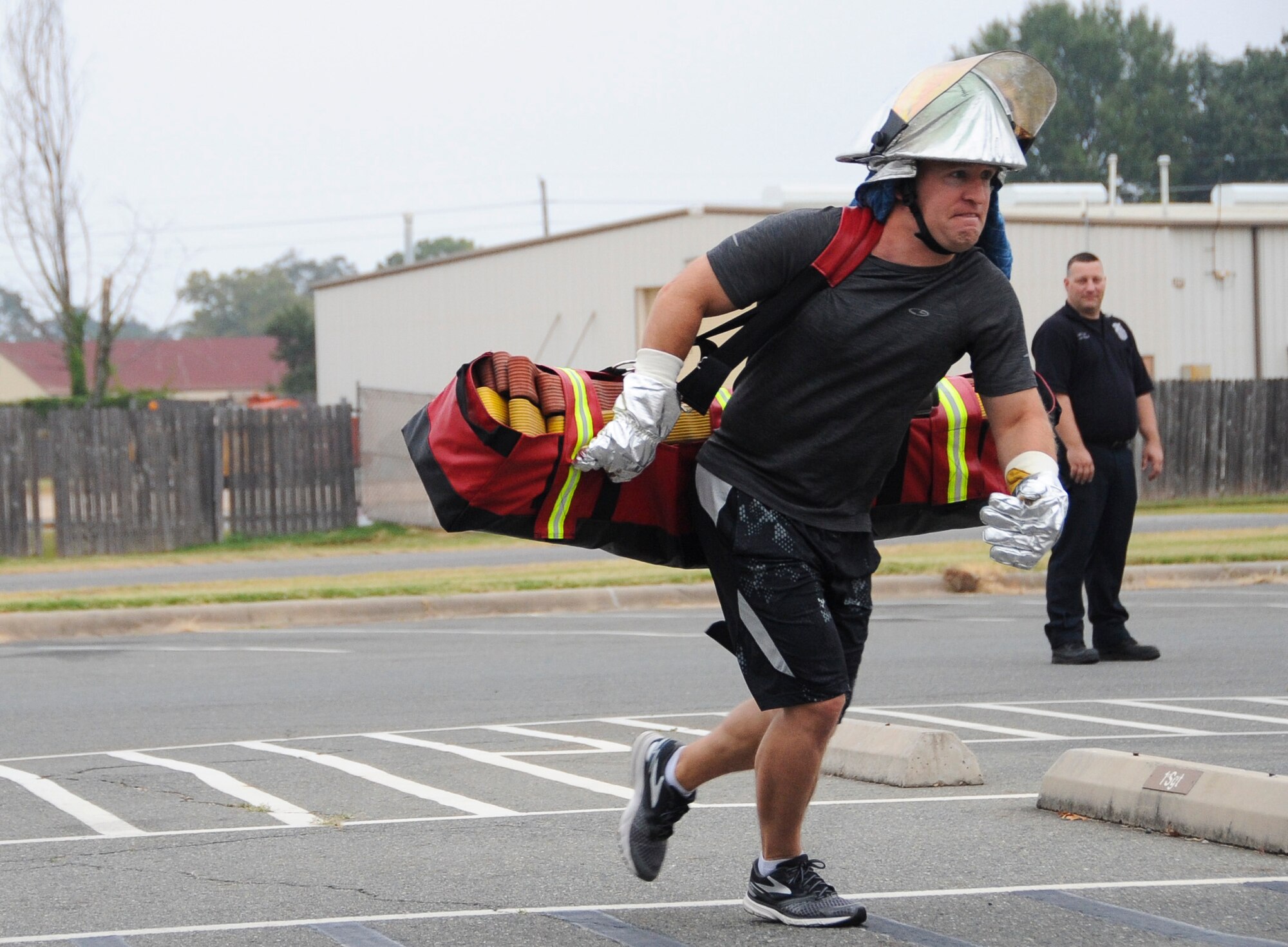 An Airman participates in the hotel pack challenge during a fire muster competition at Barksdale Air Force Base, La., Oct. 13, 2016. This obstacle demonstrates carrying equipment to a burning building. (U.S. Air Force photo/Airman Alexis C. Schultz)