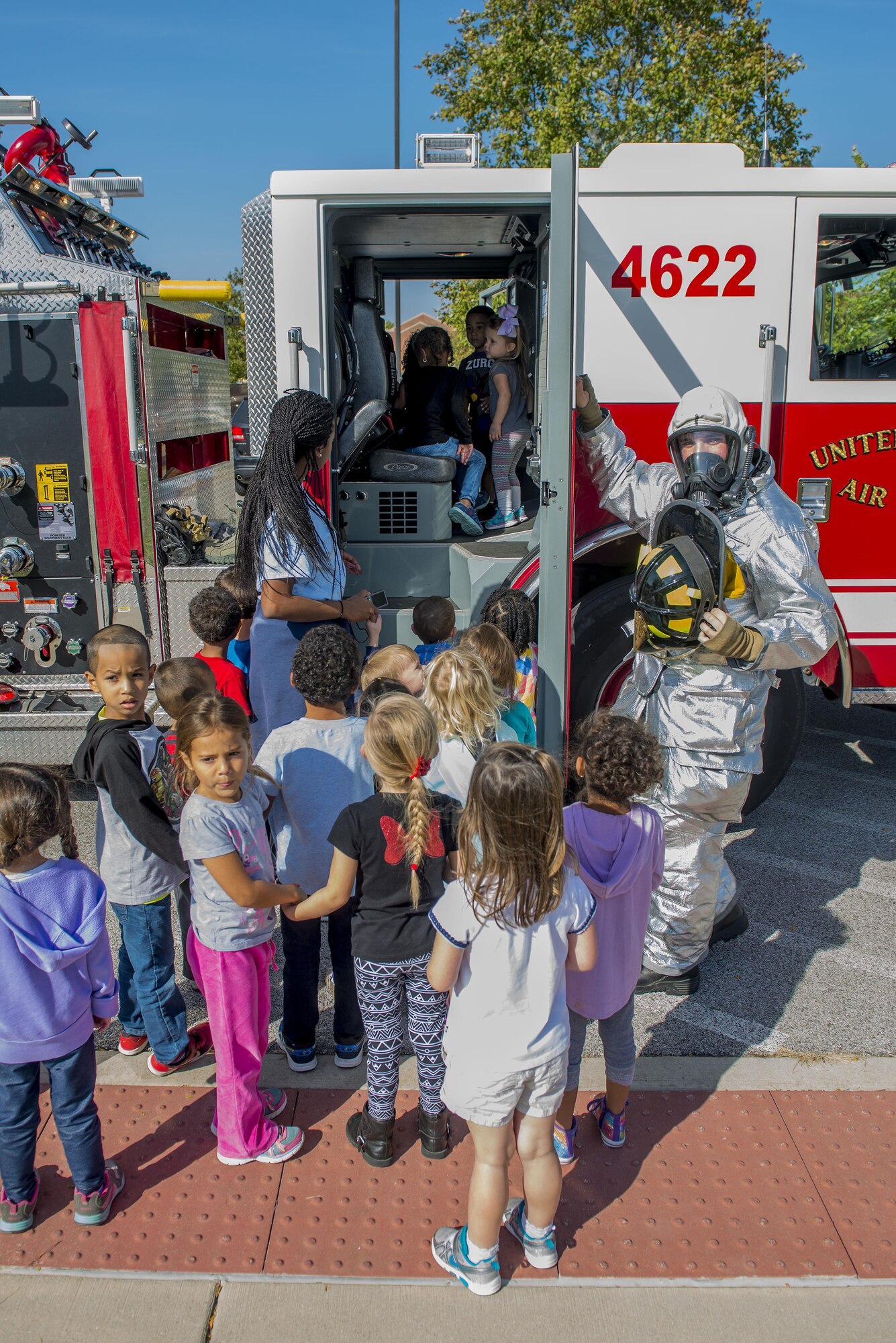 Airman Patrick McLoughlin, 375th Civil Engineering Squadron firefighter, shows the inside of a fire truck during a presentation to children at the Child Development Center for Fire Prevention Week October 14, 2016. This year’s Fire Prevention Week campaign, “Don’t Wait – Check the Date! Replace Smoke Alarms Every 10 Years,” represents the final year of our three-year effort to educate the public about basic but essential elements of smoke alarm safety. (U.S. Air Force photo by Senior Airman Joshua Eikren)