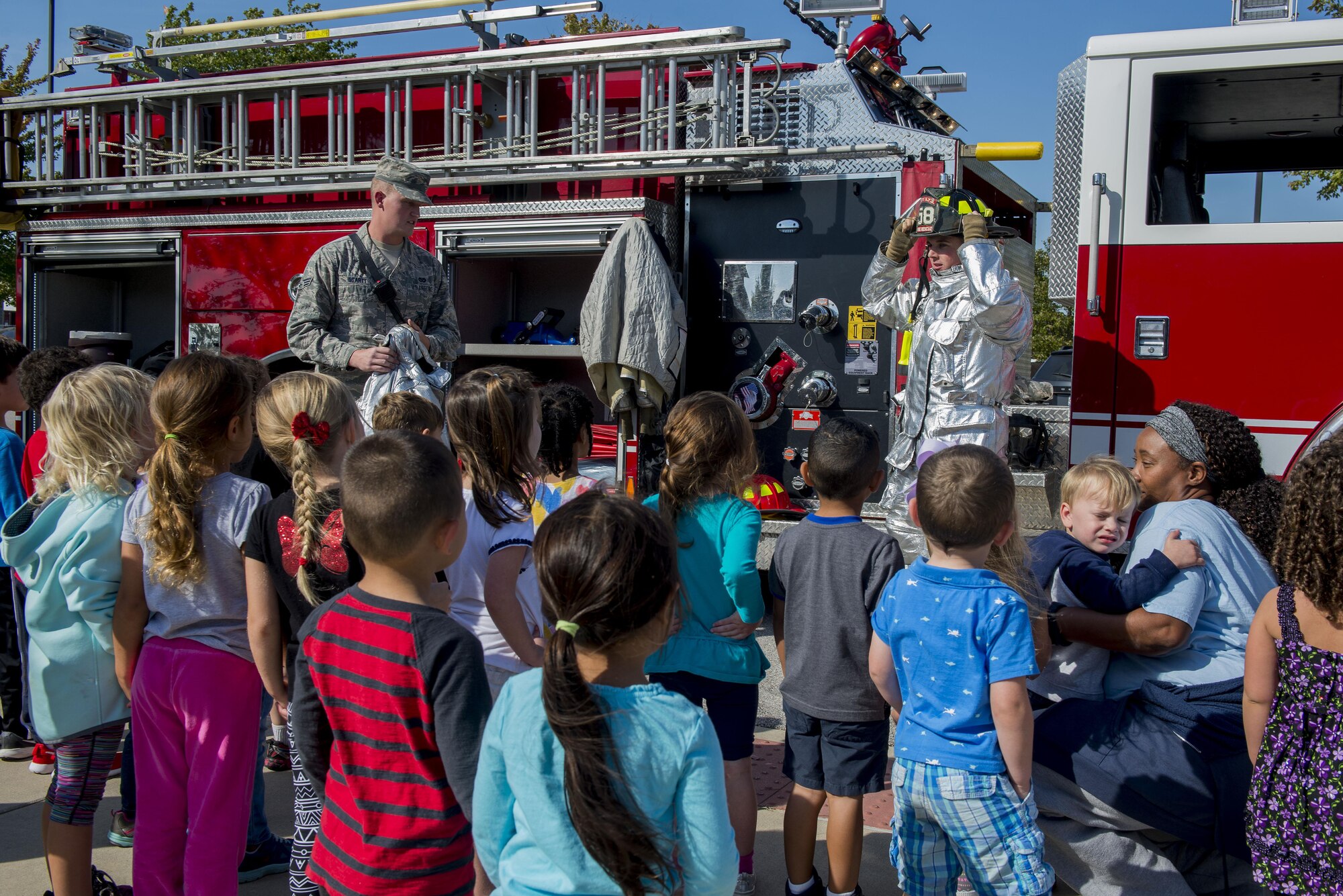 Senior Airman Tyler Startt and Airman Patrick McLoughlin, 375th Civil Engineering Squadron firefighters, give a demonstration to children at the Child Development Center during fire prevention week, October 11, 2016. This year’s Fire Prevention Week campaign, “Don’t Wait – Check the Date! Replace Smoke Alarms Every 10 Years,” represents the final year of our three-year effort to educate the public about basic but essential elements of smoke alarm safety. (U.S. Air Force photo by Senior Airman Joshua Eikren)