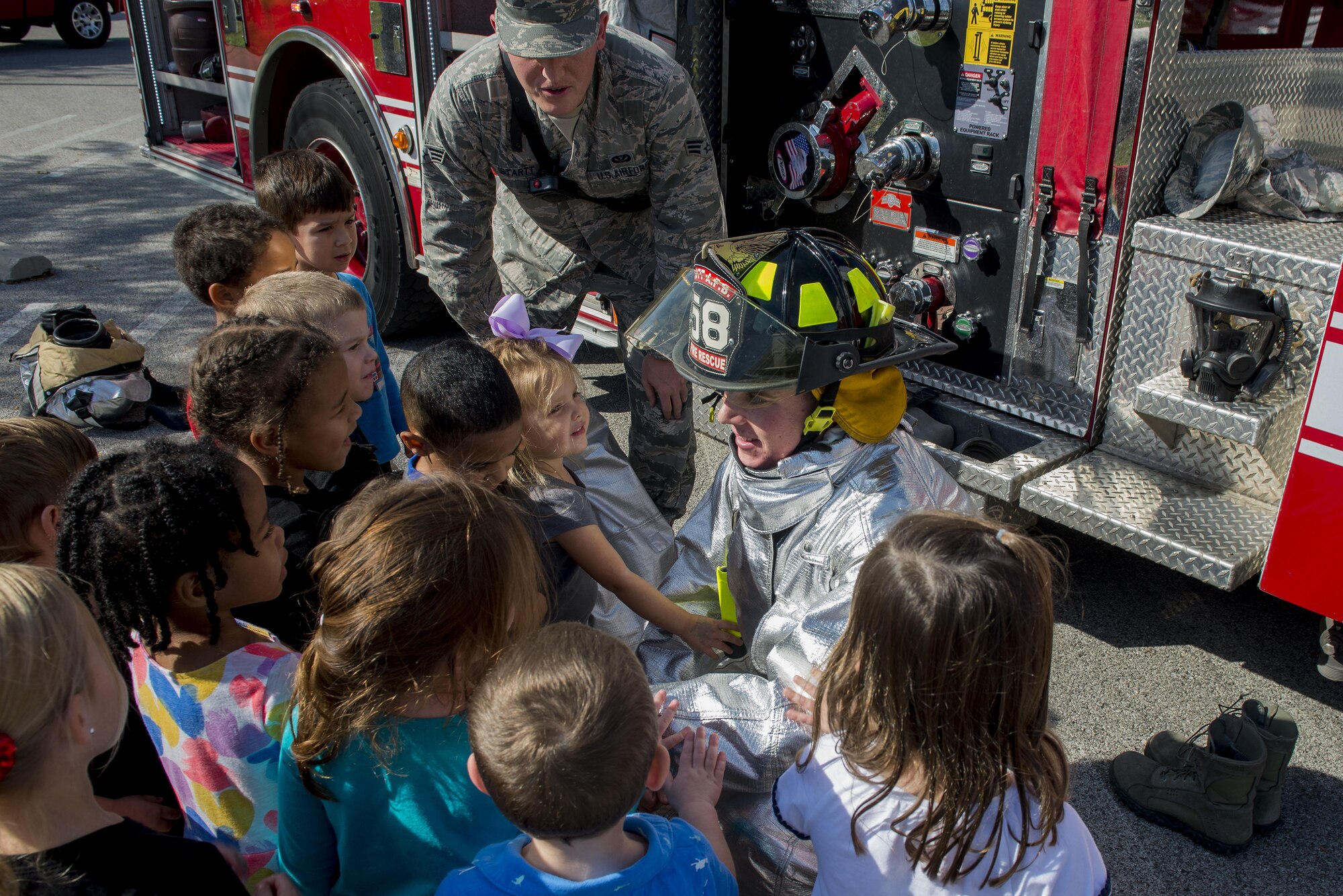 Airman Patrick McLoughlin, 375th Civil Engineering Squadron firefighter, shows a fire suit to children to familiarize kids with the appearance of firefighters during fire prevention week, October 11, 2016 at the Child Development Center. This year’s Fire Prevention Week campaign, “Don’t Wait – Check the Date! Replace Smoke Alarms Every 10 Years,” represents the final year of our three-year effort to educate the public about basic but essential elements of smoke alarm safety. (U.S. Air Force photo by Senior Airman Joshua Eikren)