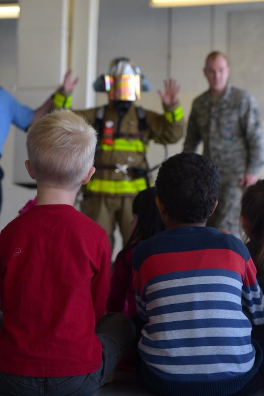 Students from Samuel P. Langley Elementary School, Hampton Va., watch as Langley Air Force Base firefighters put on their safety equipment at Joint Base Langley-Eustis, Va., Oct. 12, 2016. The firefighters explained how each piece of equipment works and why they use it as part of their safety gear. (U.S. Air Force photo by Senior Airman Kimberly Nagle)