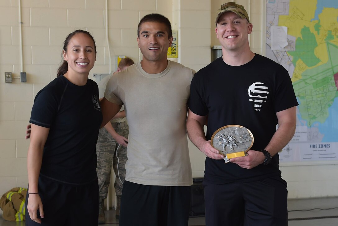 Members of the 497th Intelligence, Surveillance and Reconnaissance Group and 30th Intelligence Squadron, pose with their trophy after winning the Combat Challenge at Joint Base Langley-Eustis, Va., Oct. 14, 2016. The Combat Challenge was used as an interactive way to promote Fire Prevention Week. (U.S. Air Force photo by Senior Airman Kimberly Nagle) 
