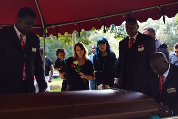 Albessa Smith, middle, widow of the late Staff Sgt. Darryl Smith, 509th Medical Support Squadron laboratory technician, Whiteman Air Force Base, Mo., holds her son, Luke, as her sister, Zarah Ramos, watches Darryl’s casket lower into the ground during his funeral, Oct. 17, 2016, in Sparr, Fla. Darryl was buried near his hometown of Citra, Fla. (U.S. Air Force photo by Airman 1st Class Greg Nash)