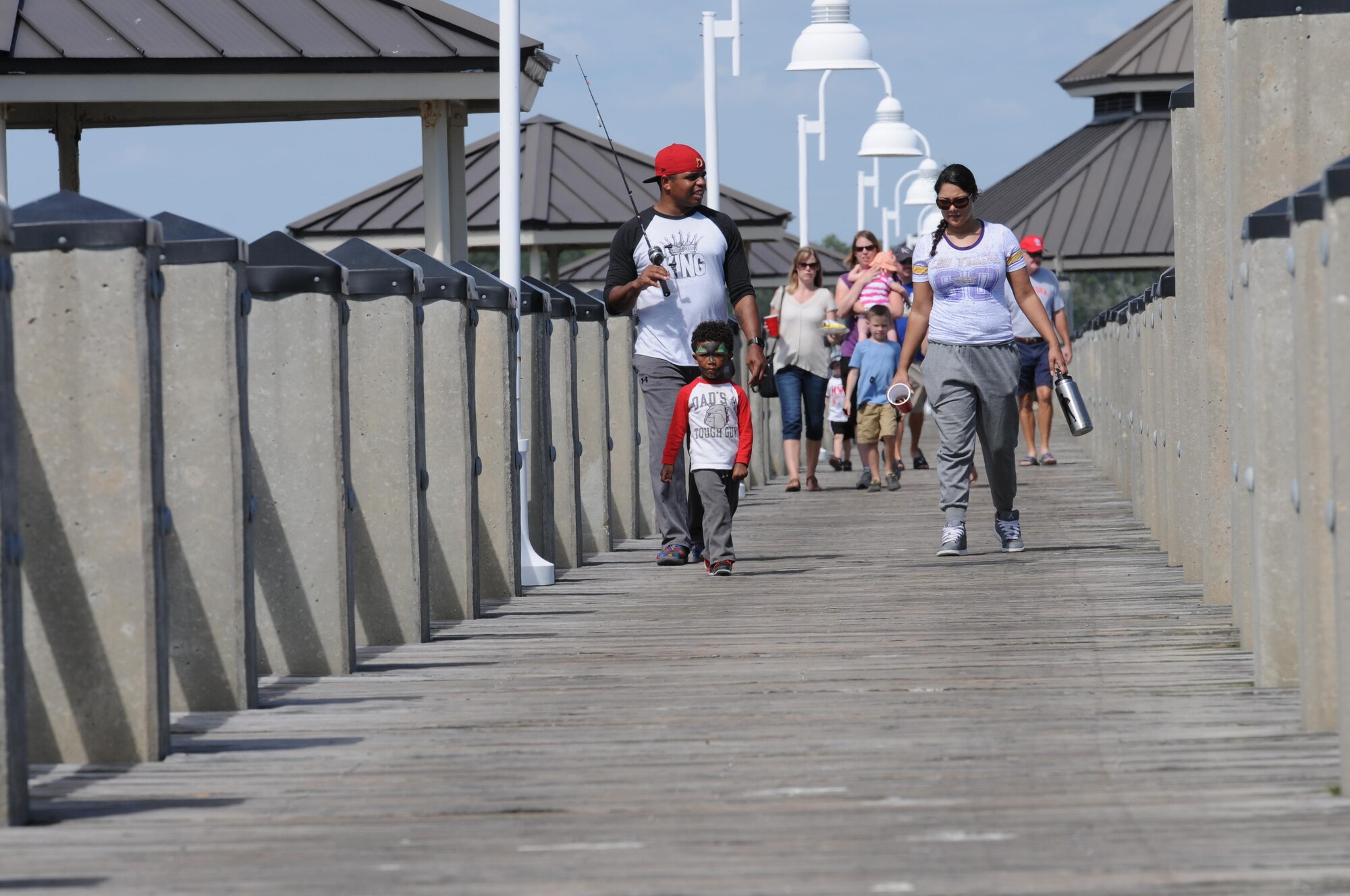 Staff Sgt. Courtney Hill, 81st Security Forces Squadron pass and ID NCO in charge, and Airman 1st Class Brittany Hill, 81st Comptroller Squadron customer service technician, and their son, Courtney Hill II, walk on the pier during the Kids’ Fishing Rodeo at the marina Oct. 15, 2016, on Keesler Air Force Base, Miss. Over 90 participants attended the event where prizes were awarded for different categories and free food was available.  (U.S. Air Force photo by Kemberly Groue/Released)