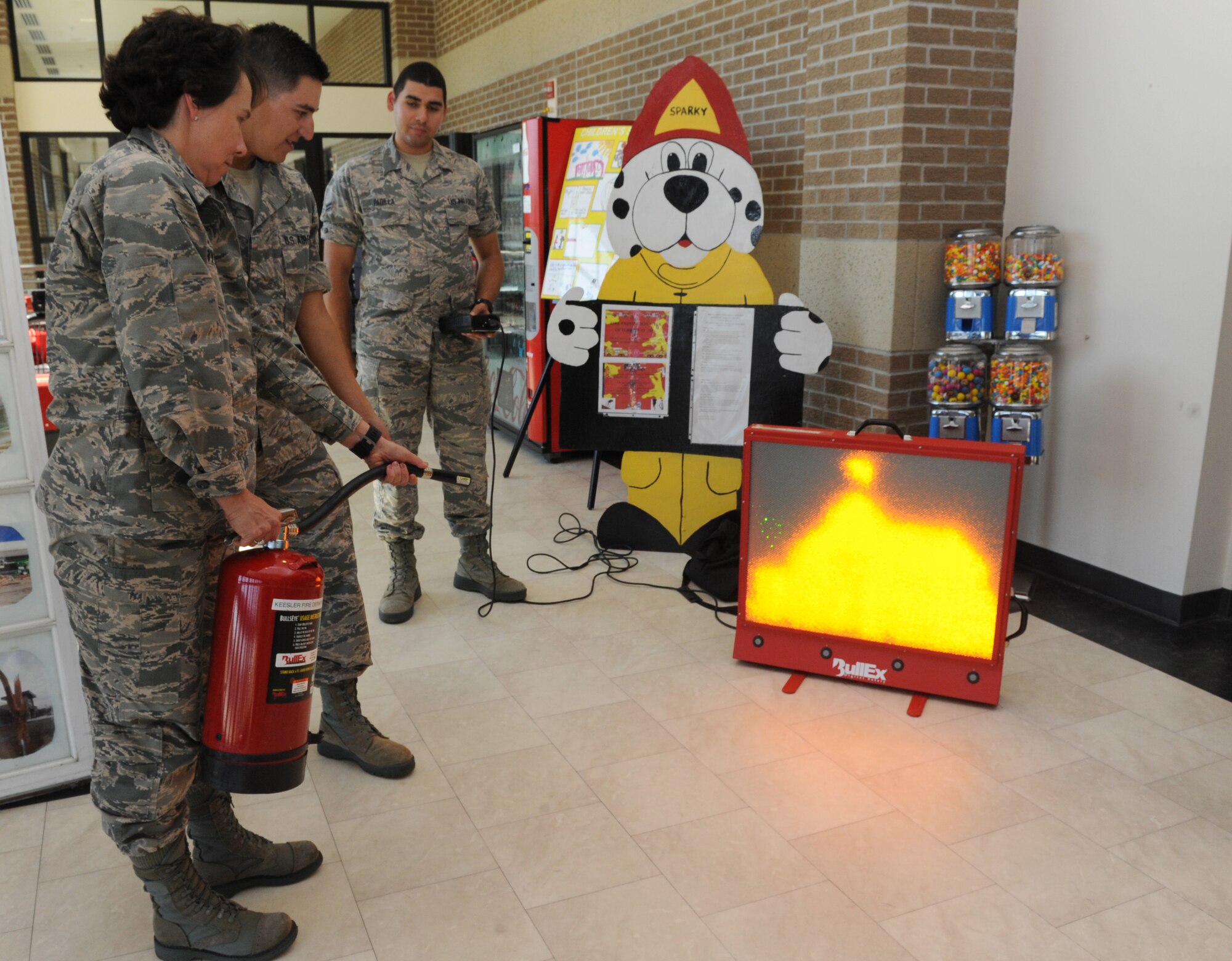 Col. Jeannine Ryder, 81st Medical Group commander, uses an electric fire extinguisher during Fire Prevention Week at the Base Exchange Oct. 11, 2016, on Keesler Air Force Base, Miss. The week-long event included fire drills, literature hand-outs and stove fire demonstrations around the base and concluded with an open house at the fire department. (U.S. Air Force photo by Kemberly Groue/Released)