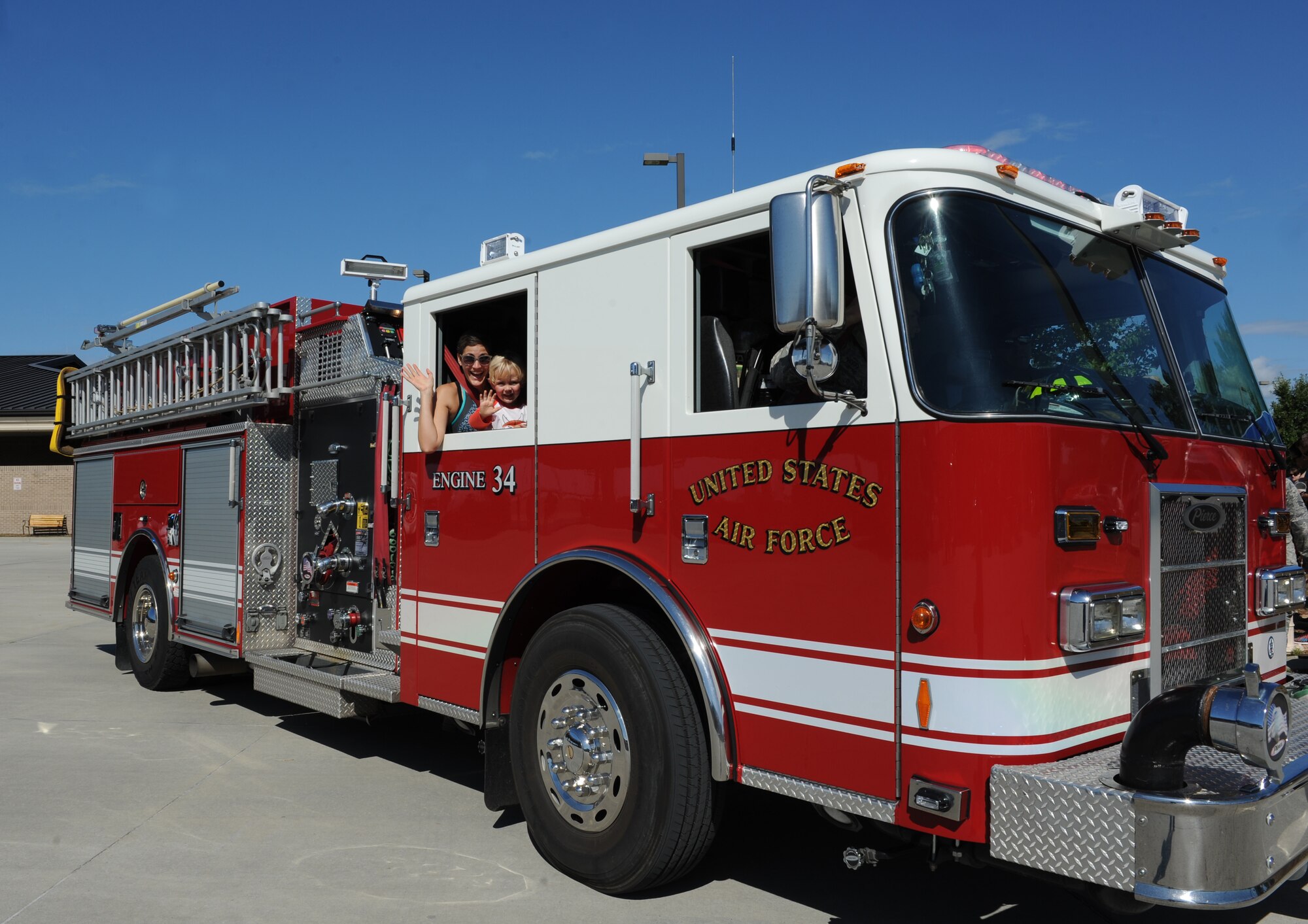 Jennifer and Peter Anderson, family of Capt. Jess Anderson, 81st Medical Operations Squadron internal medicine resident, wave from a fire truck window during the Fire Prevention Week open house at the Keesler Fire Department Oct. 15, 2016, on Keesler Air Force Base, Miss. Throughout the week the Keesler Fire Department conducted fire drills, toured various facilities with Sparky the Fire Dog, passed out fire safety information and fire hats for children and provided stove and fire extinguisher demonstrations. (U.S. Air Force photo by Kemberly Groue/Released)