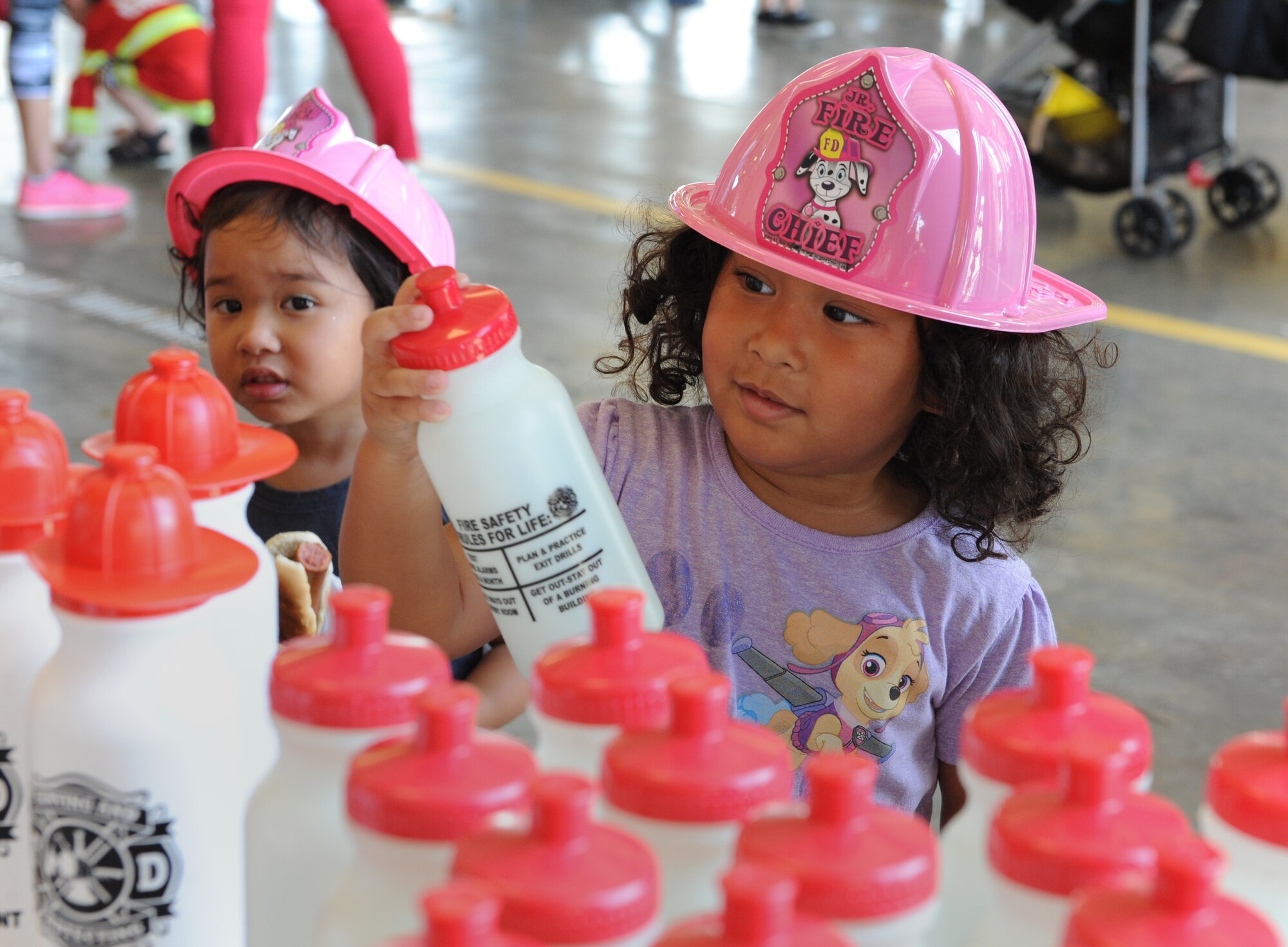Zoe and Ivy Macias, daughters of Staff Sgt. Cameron Macias, 331st Recruiting Squadron recruiter, Slidell, La., collect gifts during the Fire Prevention Week open house at the Keesler Fire Department Oct. 15, 2016, on Keesler Air Force Base, Miss. Throughout the week the Keesler Fire Department conducted fire drills, toured various facilities with Sparky the Fire Dog, passed out fire safety information and fire hats for children and provided stove and fire extinguisher demonstrations. (U.S. Air Force photo by Kemberly Groue/Released)