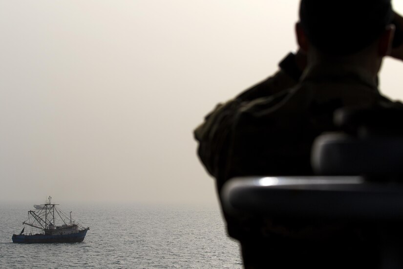 A Soldier from the 411th Transportation Detachment looks out from the bridge of the MG Charles P. Gross (Logistics Support Vessel-5) at a Kuwaiti fishing boat in the Arabian Gulf, October 3, 2016. The ship is responsible for moving cargo throughout the U.S. Army Central area of operations, including Qatar, United Arab Emirates and Bahrain.  (U.S. Army photo by Sgt. Brandon Hubbard, USARCENT Public Affairs)