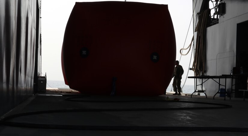 A Soldier from the 411th Transportation Detachment stands next to a “Killer Tomato” inflatable target on the MG Charles P. Gross (Logistics Support Vessel-5) traveling into international waters in the Arabian Gulf, October 3, 2016. The unit, from Fort Eustis, Va. and based at Kuwait Naval Base, fire crew-served weapons at the targets about four times per year to maintain defensive readiness. (U.S. Army photo by Sgt. Brandon Hubbard, USARCENT Public Affairs)