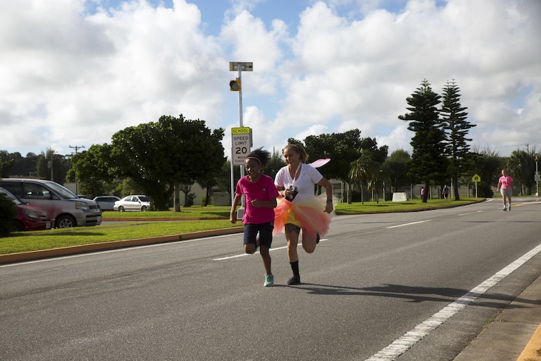 Participants cross the finish line after completing the Second Annual Breast Cancer Awareness 5-kilometer Run Oct. 1 aboard Camp Lester, Okinawa, Japan. The event brought Status of Forces Agreement members together to show support for survivors of breast cancer. The 5-km. event is one of the many Marine Corps Community Services Health Promotion events that brings the community together and promotes a healthy lifestyle in the military community. (U.S. Marine Corps photo by Cpl. Janessa K. Pon / Released)