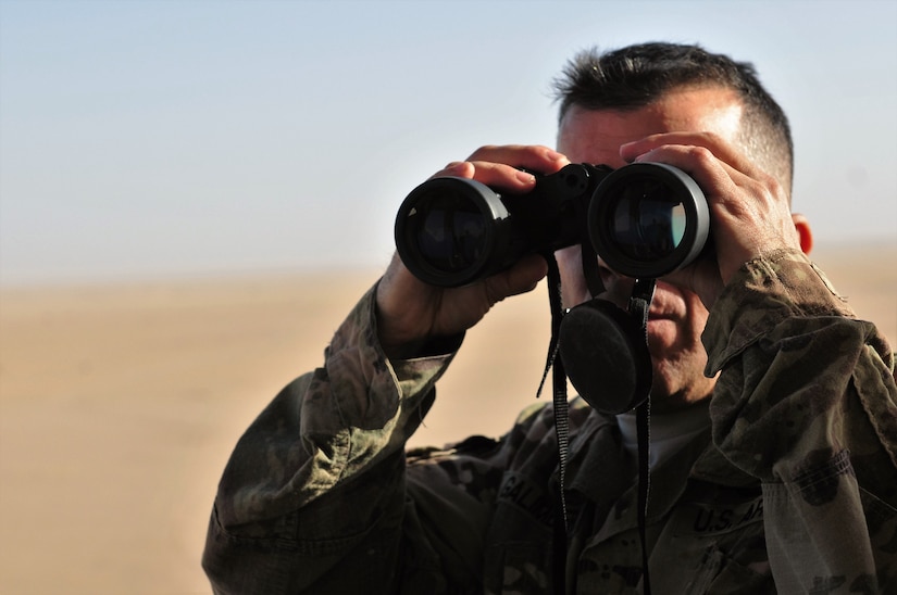 Sgt. 1st Class Dennis Galimberti, a forward observer with 1st Battalion, 94th Field Artillery Regiment, scans the firing site and impact zone for possible interferences during a decisive action training environment exercise on Oct. 4, 2016 near Camp Buehring, Kuwait. (U.S. Army photo by Sgt. Aaron Ellerman)