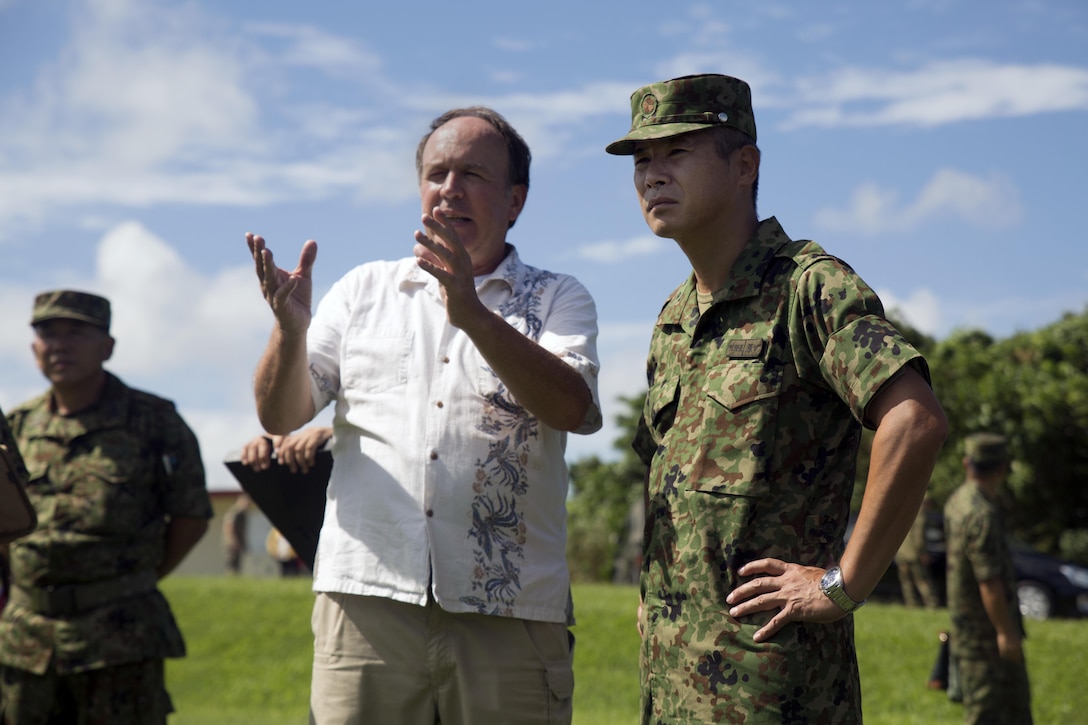 Patrick Adams, left, discusses the training scheduled to take place during the annual Guard and Protect, an observe and exchange event with Japan Ground Self-Defense Force Maj. Gen. Tomofusa Hanada Oct. 7 on Marine Corps Air Station Futenma, Okinawa, Japan. The three-day exchange allowed U.S. and JGSDF service members to sharpen their defense skill sets and strengthen their bilateral relationship by allowing them to observe and exchange each other’s tactical procedures. The event covered methods of troop movement, rules of engagement, and vehicle search and seizure. Hanada is the commanding general of the JGSDF 15th Brigade. Adams is the installation protection director of MCAS Futenma.