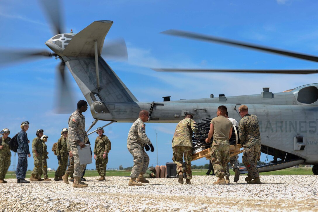 Service members attached to Joint Task Force Matthew load supplies onto a CH-53E Super Stallion helicopter assigned to Marine Medium Tiltrotor Squadron 365 for aid delivery in Port-au-Prince, Haiti, Oct. 17, 2016. JTF Matthew is providing humanitarian aid and disaster relief to Haiti following Hurricane Matthew. Navy photo by Petty Officer 2nd Class Andrew Murray