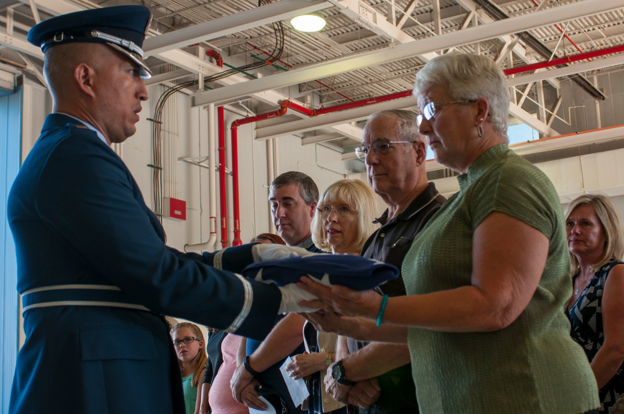 Capt. Jason Gonzales the Logistics and Readiness Squadron commander presents the flag to retired Maj. Gen. Donald E. Morris’s daughter Nancy Morris at a ceremony here October 14.  The ceremony honored the life and memory of Morris, the unit’s first and longest serving commander who died June 7, 2016. (U.S. Air National Guard photo by 1st Lt. Lacey Roberts)