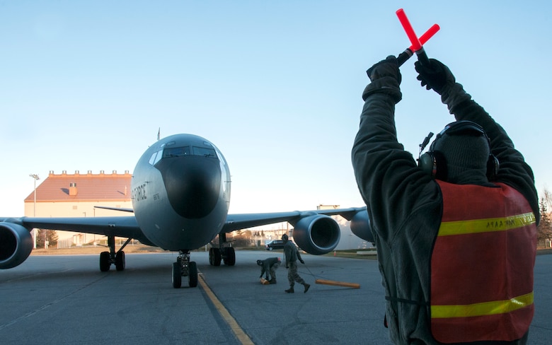 Tech Sgt. Ezra Pitzer, crew chief with the 168th Aircraft Maintenance Squadron, communicates with the aircraft pilot by signaling from the flight line outside of the unit’s hangar at Eielson AFB, Alaska, October 16, 2016. The pilot of the KC-135R Stratotanker listens and watches as the crew chief directs both aircraft and ground personnel during taxiing in order to safely park the aircraft. (U.S. Air National Guard photo by Senior Master Sgt. Paul Mann/Released)