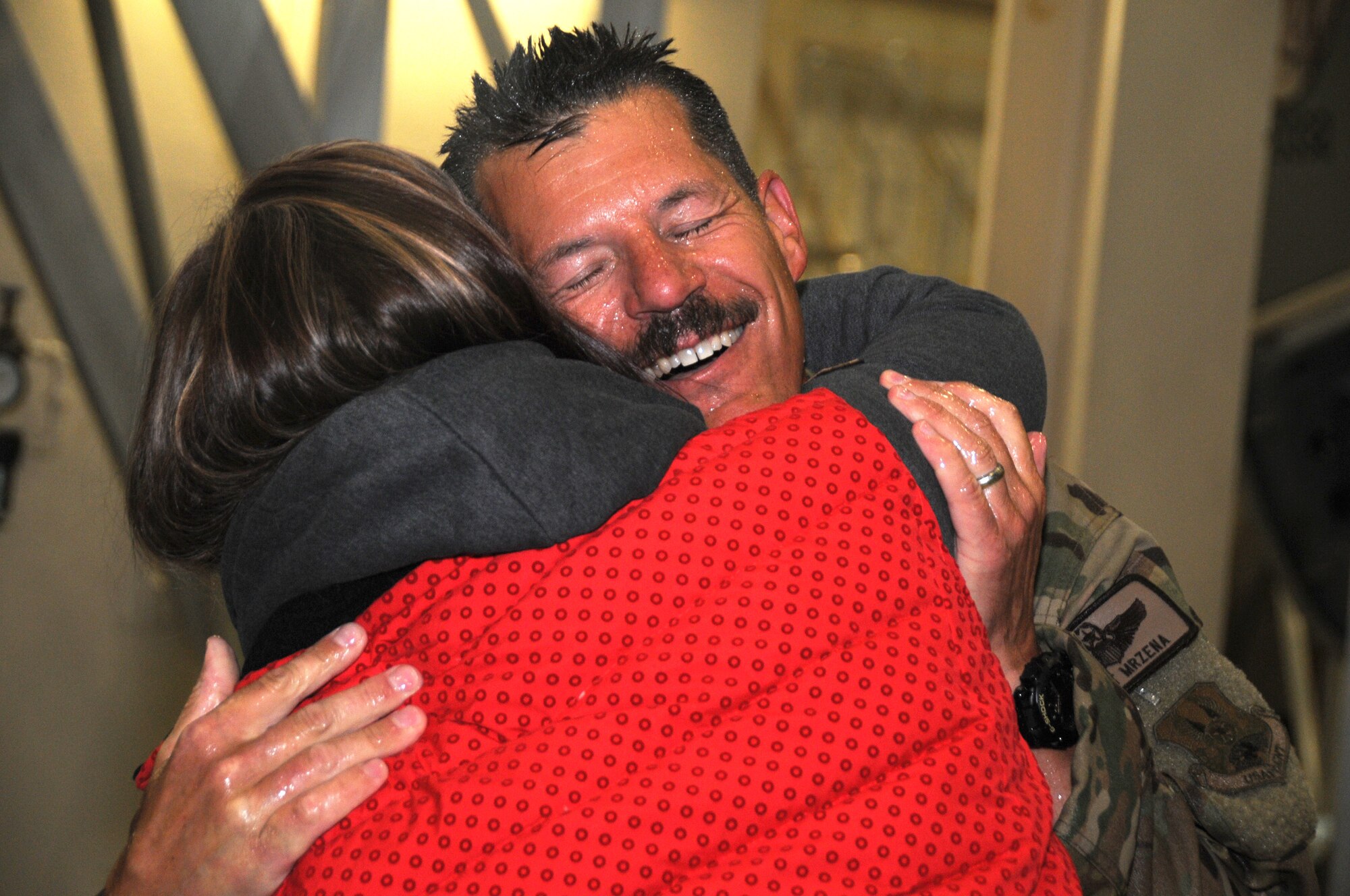 Lt. Col. Matthew Mrzena, instructor pilot from the 168th Air Refueling Squadron, is welcomed home by family and friends after a two-month deployment in Southwest Asia. As part of a military tradition, Mrzena was drenched in water upon arrival because today’s flight was his last as a member of the Alaska Air National Guard. (U.S. Air National Guard photo by Airman 1st Class Mae S. Olson/Released)