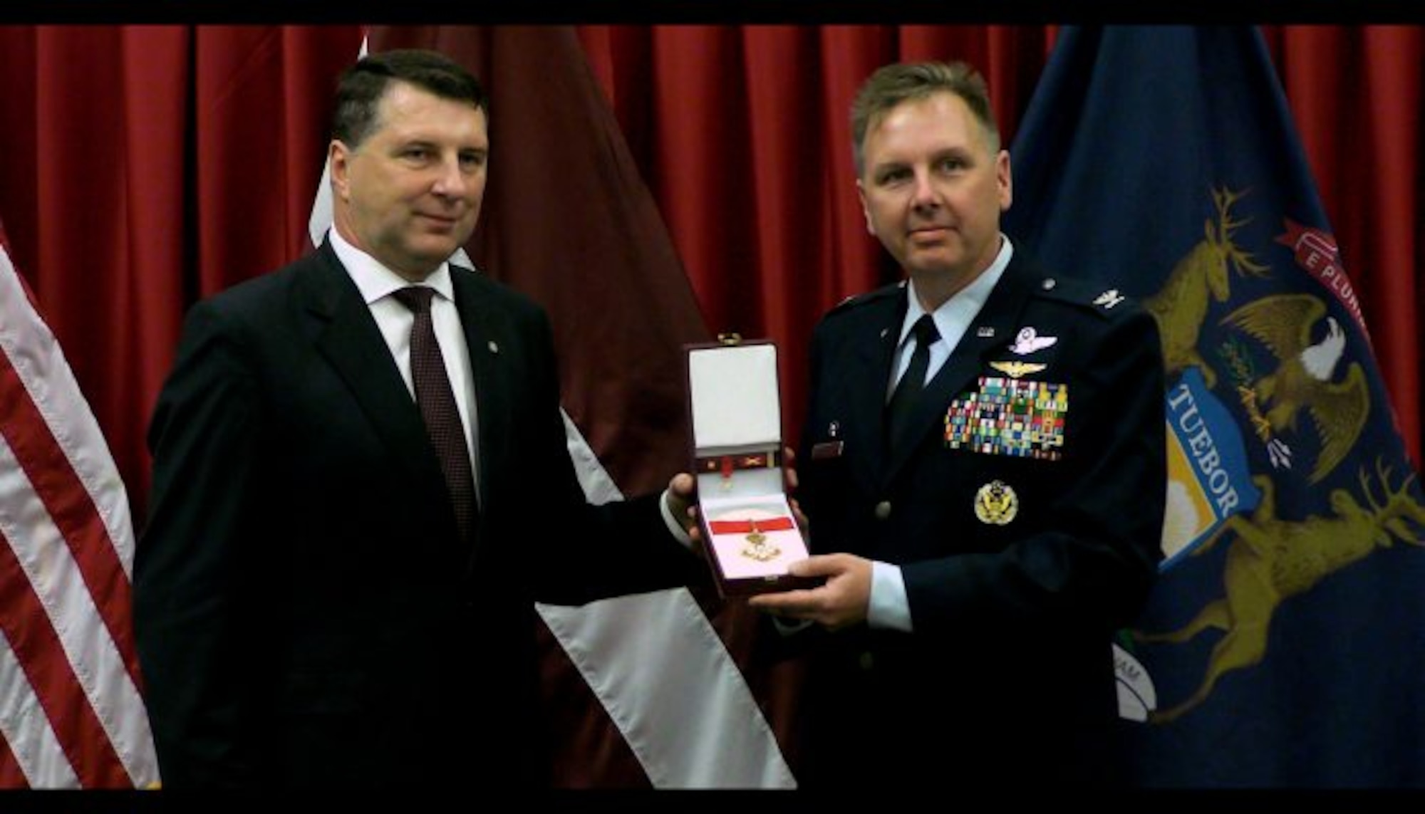 The President of the Republic of Latvia (left) presented Col. J. Andrew Roberts, commander of the Alpena Combat Readiness Training Center, with the Order of Viesturs medal, Sept. 23, 2016, at the Michigan National Guard headquarters facility in Lansing. The Order of Viesturs is presented only by the President and was given to Roberts to recognize his efforts toward strengthening the country and promoting joint learning between military forces. Roberts served as the bilateral affairs officer to Latvia in 2012 and 2013. (Michigan National Guard photo by Angela Simpson/released).