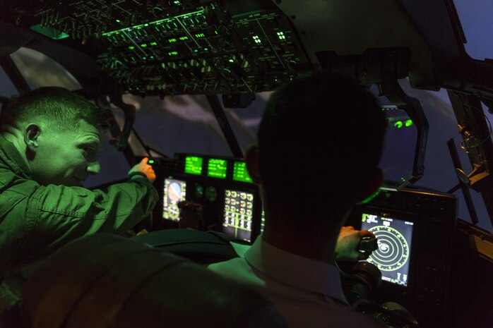 U.S. Marine Corps Capt. Donald Shrewsbury, a KC-130J Hercules representative  with Marine Aviation Training System Site Iwakuni, directs a Japan Air Self-Defense Force aviation cadet with the 12th Flight Training Wing from JASDF Hōfu-kita Air Base while flying a KC-130J simulator during a Junior officer engagement program at Marine Corps Air Station Iwakuni, Japan, Oct. 19, 2016. The engagement program aims to enhance the understanding and working relationships between U.S. and Japanese pilots. (U.S. Marine Corps photo by Lance Cpl. Aaron Henson)