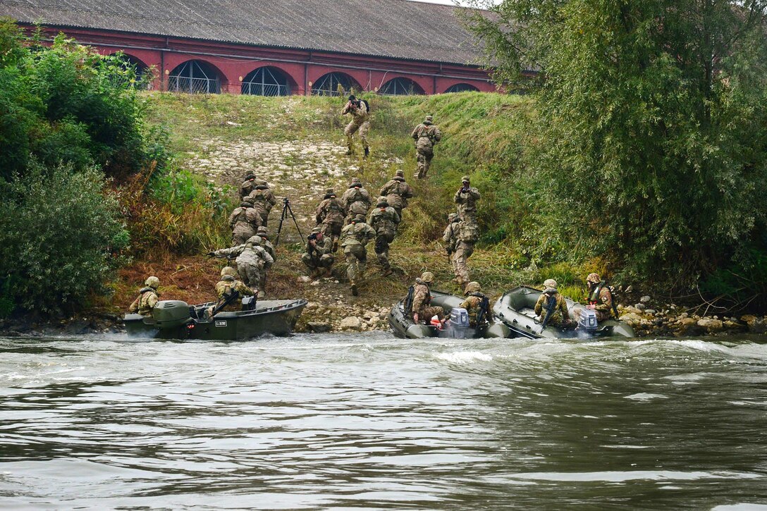 U.S. paratroopers and Italian soldiers rush up a river bank and advance toward their next objective during Livorno Shock 16, an exercise in Piacenza, Italy, Oct. 17, 2016. Army photo by Massimo Bovo