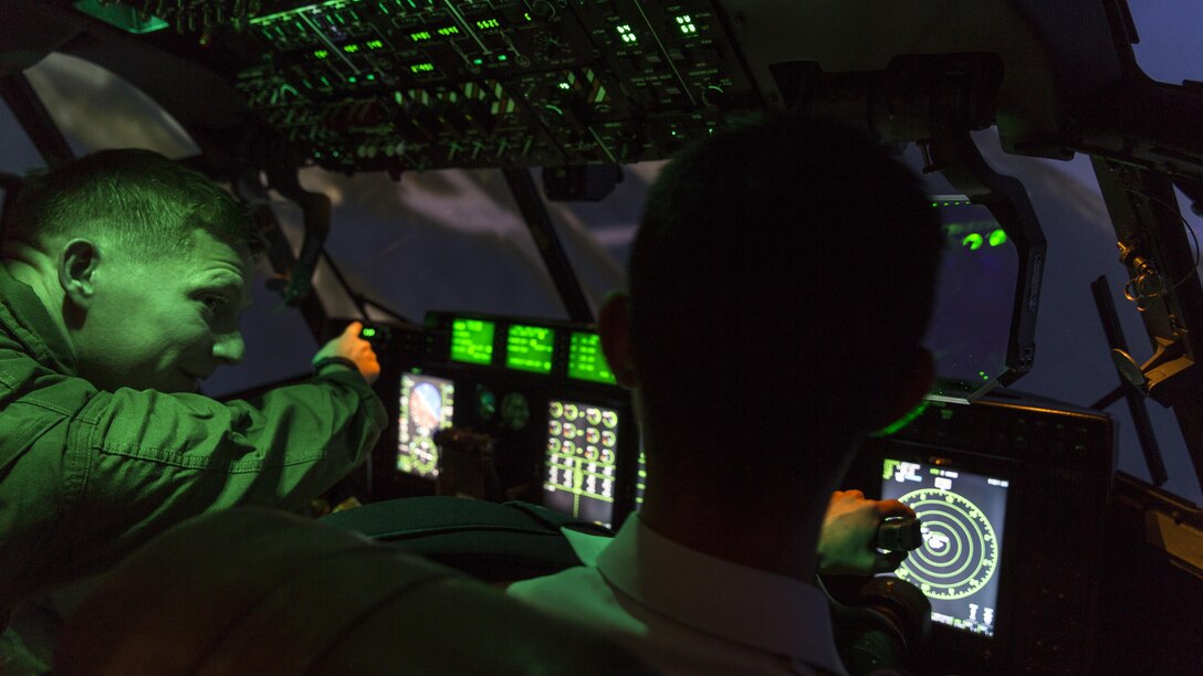 U.S. Marine Corps Capt. Donald Shrewsbury, a KC-130J Hercules representative  with Marine Aviation Training System Site Iwakuni, directs a Japan Air Self-Defense Force aviation cadet with the 12th Flight Training Wing from JASDF Hōfu-kita Air Base while flying a KC-130J simulator during a Japanese officer engagement program at Marine Corps Air Station Iwakuni, Japan, Oct. 19, 2016. The engagement program aims to enhance the understanding and working relationships between U.S. and Japanese pilots. 