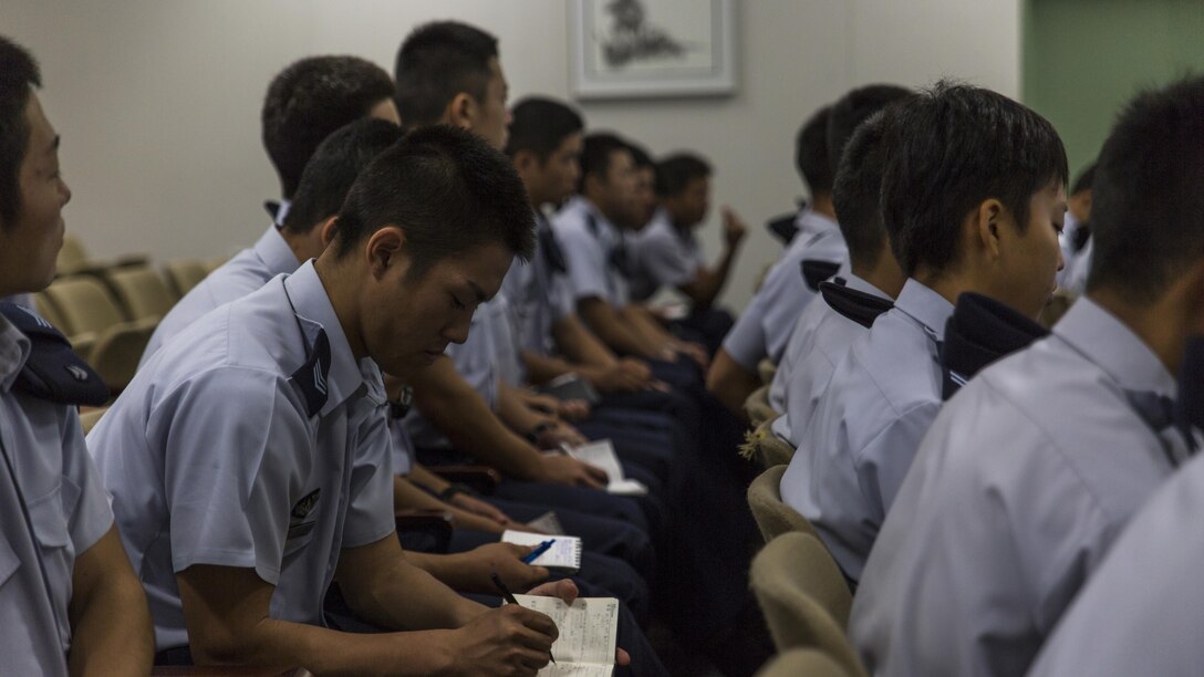 Japan Air Self-Defense Force aviation cadets with the 12th Flight Training Wing from JASDF Hōfu-kita Air Base takes notes during a Japanese officer engagement program at Marine Corps Air Station Iwakuni, Japan, Oct. 19, 2016. During the visit, approximately 40 cadets toured the air station to see an F/A-18D Hornet assigned to Marine All-Weather Fighter Attack Squadron 225 and a KC-130J Hercules belonging to Marine Aerial Refueler Transport Squadron 152. Cadets also took turns flying a KC-130J flight simulator and learned about Marine Aircraft Group 12 and the air station.