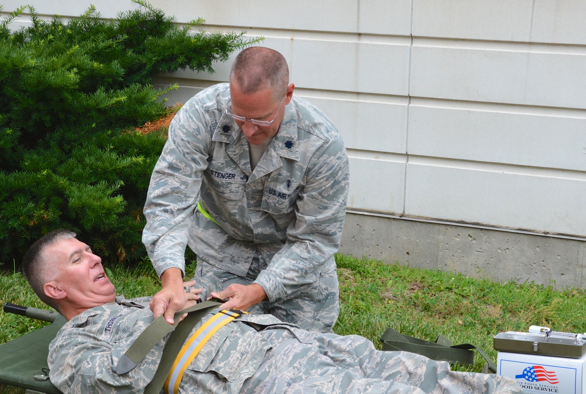 Chaplain (Lt. Col.) William Thornton plays the part of a "patient" and is attended to by Lt. Col. James Stenger of the Medical Squadron.  Members of the 932nd Airlift Wing participated in a patient movement exercise at Scott Air Force Base, Ill. earlier in the summer. During the exercise, medical teams from the 932nd Medical Squadron and 932nd Aeromedical Staging Squadron worked in a simulated deployed environment to safely transport patients from the hospital to a staging area before loading them onto a C-130 Hercules aircraft. The training exercise emphasized the breadth of skills necessary to deploy and operate an Expeditionary Medical Support Basic facility and a 50-bed En Route Patient Staging System. (U.S. Air Force photo by Tech. Sgt. Jodi Ames)