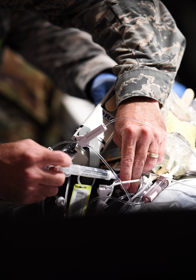Maj. JK House, 959th Medical Group clinical nurse, tends to a patient onboard an ambulance at Kelly Airfield, Joint Base San Antonio-Lackland, Texas, Oct. 15, 2016. House is part of the 59th Medical Wing’s Acute Lung Rescue Team, which is comprised of medics with extensive training of aeromedical evacuation techniques. The team transported the patient, a Navy Sailor, from the Navy Medical Center in San Diego to San Antonio for care at the San Antonio Military Medical Center on nearby Joint Base San Antonio-Fort Sam Houston. (U.S. Air Force photo/Staff Sgt. Jerilyn Quintanilla)