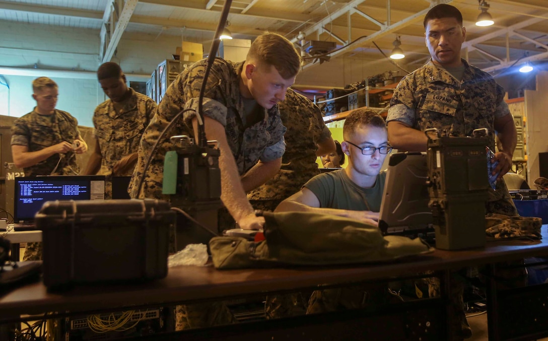Marines learn how to connect a radio to a computer during a training exercise at Camp Lejeune, N.C., Oct. 17, 2016. Four units where present for Adaptive Network Wideband Waveform training, which focused on the units configuring their equipment in order to communicate with each other without an internet service. The Marines come from various communication specialties within 2nd Marine Logistics Group. (U.S. Marine Corps photo by Lance Cpl. Ashley Lawson) 