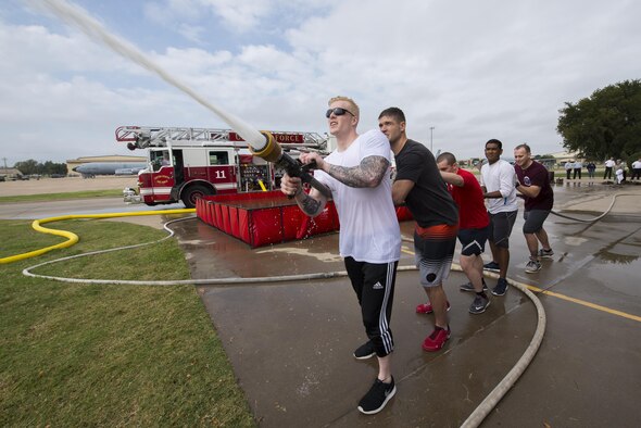 Senior Airman Gustave Bromme, 82nd Medical Support Squadron radiology technician, leads his team from the 82nd Medical Group in the Sheppard Air Force Base, Texas, firefighter challenge, Oct. 14, 2016. This challenge demonstrates various tasks firefighters might have to perform in order to fight fires and save lives. (U.S. Air Force photo by Senior Airman Kyle E. Gese)