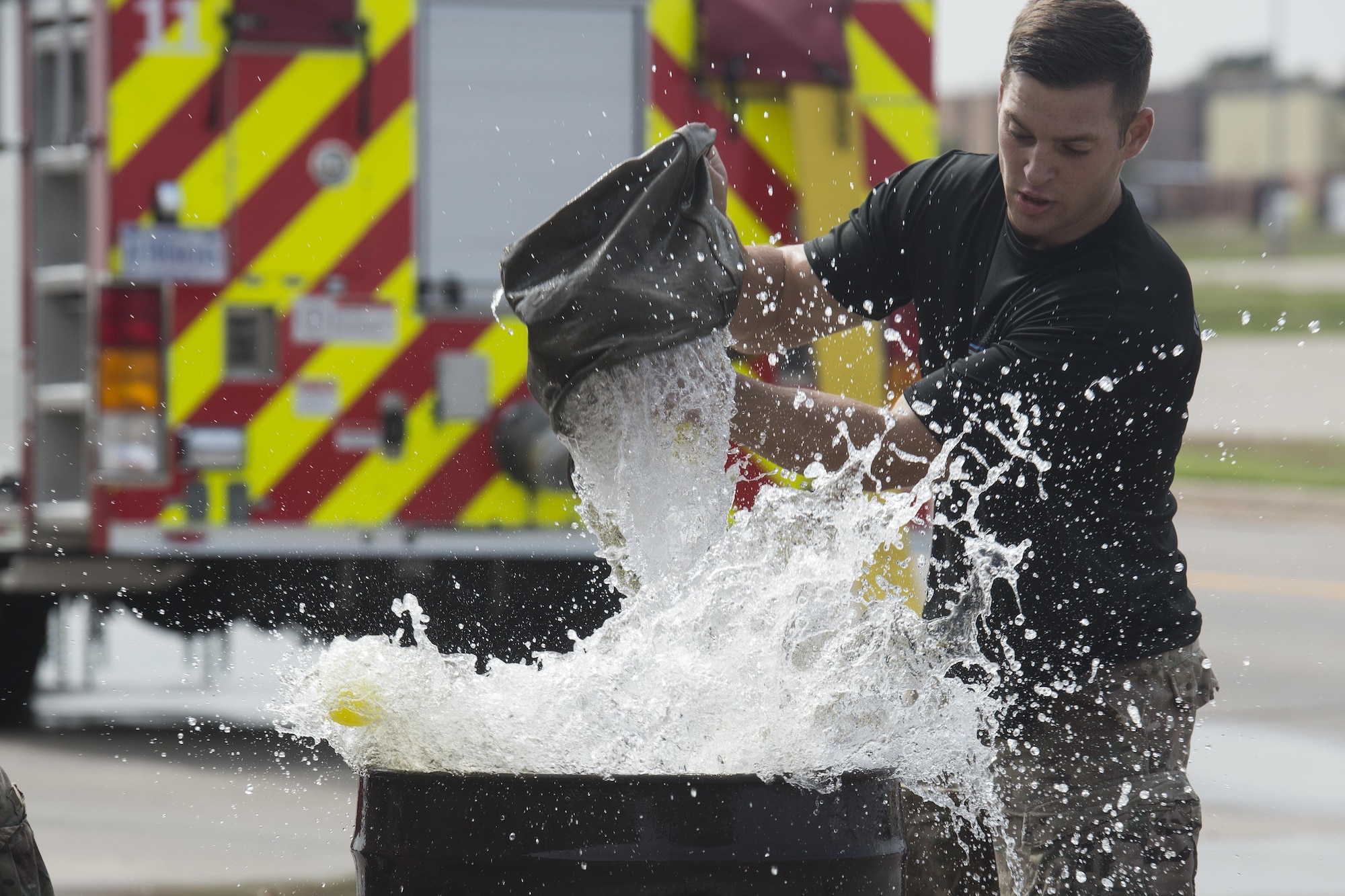 Senior Airman Carmen Pontello, 82nd Security Forces Squadron defender, rapidly fills an oil drum during the Sheppard Air Force Base, Texas, firefighter challenge, Oct. 14, 2016. The bucket brigade challenge involves transporting water from a nearby reservoir, to an empty oil drum. Each team must fill the drum until balls floating inside overflow. (U.S. Air Force photo by Senior Airman Kyle E. Gese)