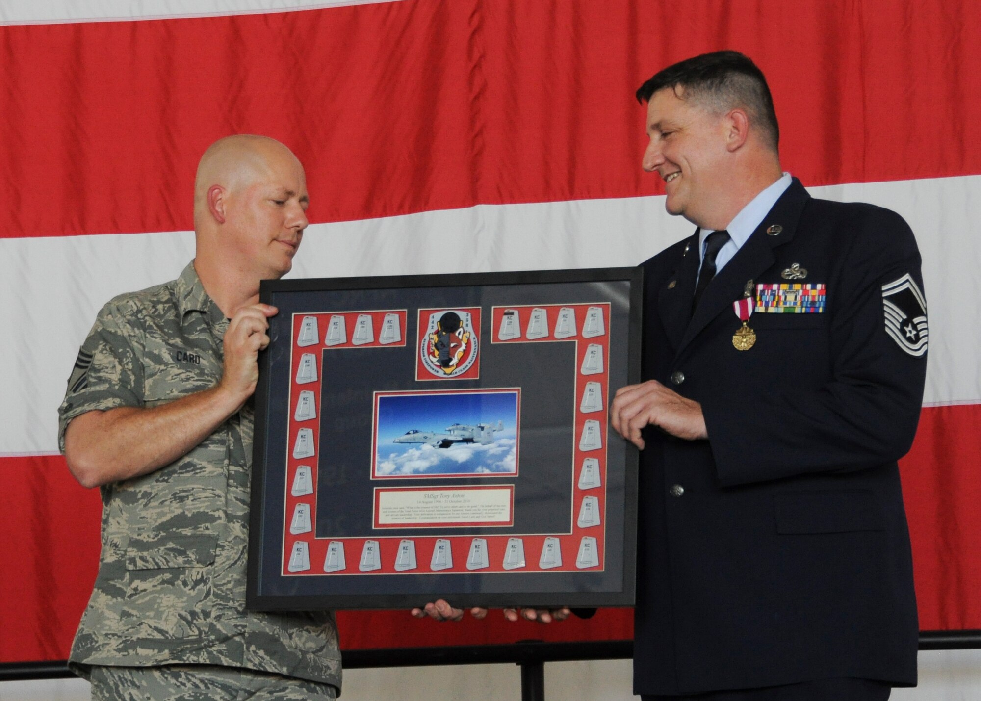 Chief Master Sgt. Brian Card, 442nd Aircraft Maintenance Squadron Weapons Flight Chief, presents a memento to Senior Master Sgt. Anthony Axton, 442nd AMXS Accessory Flight Chief, during Axton's retirement ceremony at Whiteman Air Force Base, Mo., Oct. 16, 2016. Axton was selected as the accessory flight chief in 2013 and is continuing his career as a Sexual Assault Prevention and Response victim advocate for the 509th Bomb Wing at Whiteman. (U.S. Air Force photo/Senior Airman Missy Sterling)