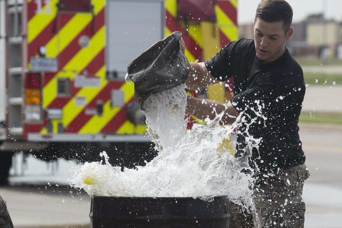 Senior Airman Carmen Pontello, 82nd Security Forces Squadron defender, rapidly fills an oil drum during the Sheppard Air Force Base, Texas, firefighter challenge, Oct. 14, 2016. The bucket brigade challenge involves transporting water from a nearby reservoir, to an empty oil drum. Each team must fill the drum until balls floating inside overflow. (U.S. Air Force photo by Senior Airman Kyle E. Gese)