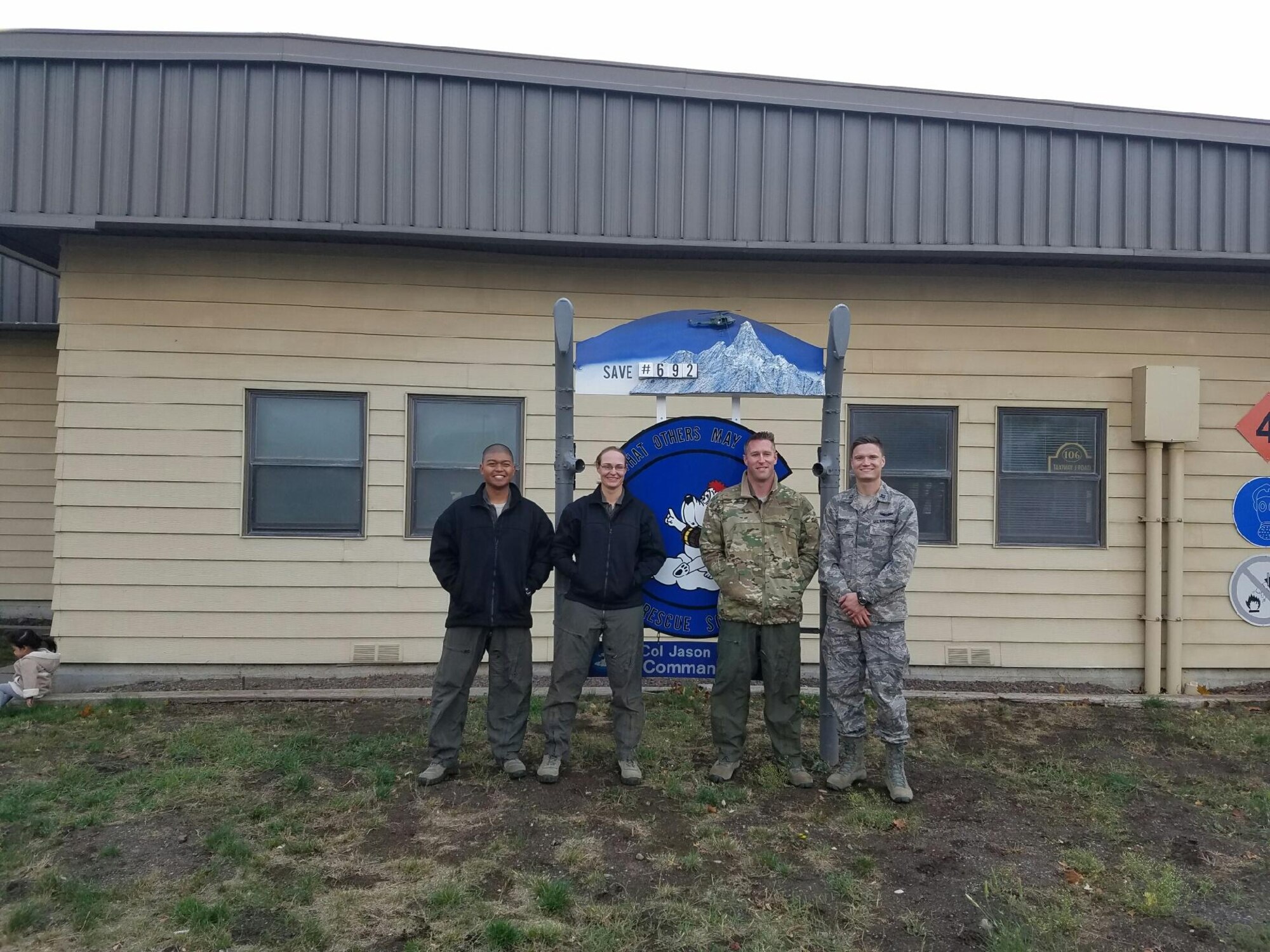 From left to right, Staff Sgt. Joseph Lopez, 36th Rescue Squadron flight engineer, Tech. Sgt. Amber Schumacher, 336th Training Support Squadron independent medical technician, Capt. Erik Greendyke, 36th RQS operations officer, and Capt. John Harris, 336th Training Group executive officer, pose with the 36th RQS squadron sign. It is squadron tradition to change the number on the sign signifying the amount of people saved by the 36th RQS. This rescue marks the 692nd save the 36th RQS has accomplished. (Courtesy photo)