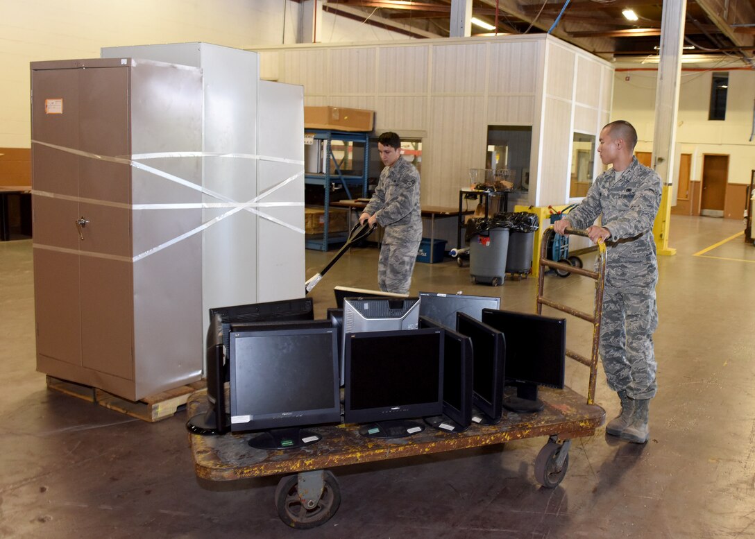 U.S. Air Force Senior Airman Jose Escobedo 97th Logistics Readiness Squadron, flight service center journeyman, and U.S. Air Force Airman Christopher Hong, 97th LRS, flight service center apprentice, move filing cabinets and computer monitors, Oct. 11, 2016, Altus Air Force Base, Okla. Escobedo and Hong work in the Defense Reutilization and Marketing Office, which houses unused items from offices on base and distributes the items as needed to other offices to help the Air Force Save money. 