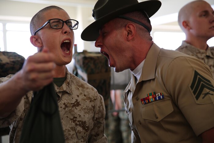 A drill instructor from Charlie Company, 1st Recruit Training Battalion, corrects a recruit during pick up at Marine Corps Recruit Depot San Diego, Oct. 14. In the first hours recruits are with their drill instructors, they learn the rules and regulations of recruit training, covering everything from how to act in the squad bay to how to speak to the drill instructors. Annually, more than 17,000 males recruited from the Western Recruiting Region are trained at MCRD San Diego. Charlie Company is scheduled to graduate Jan. 6.