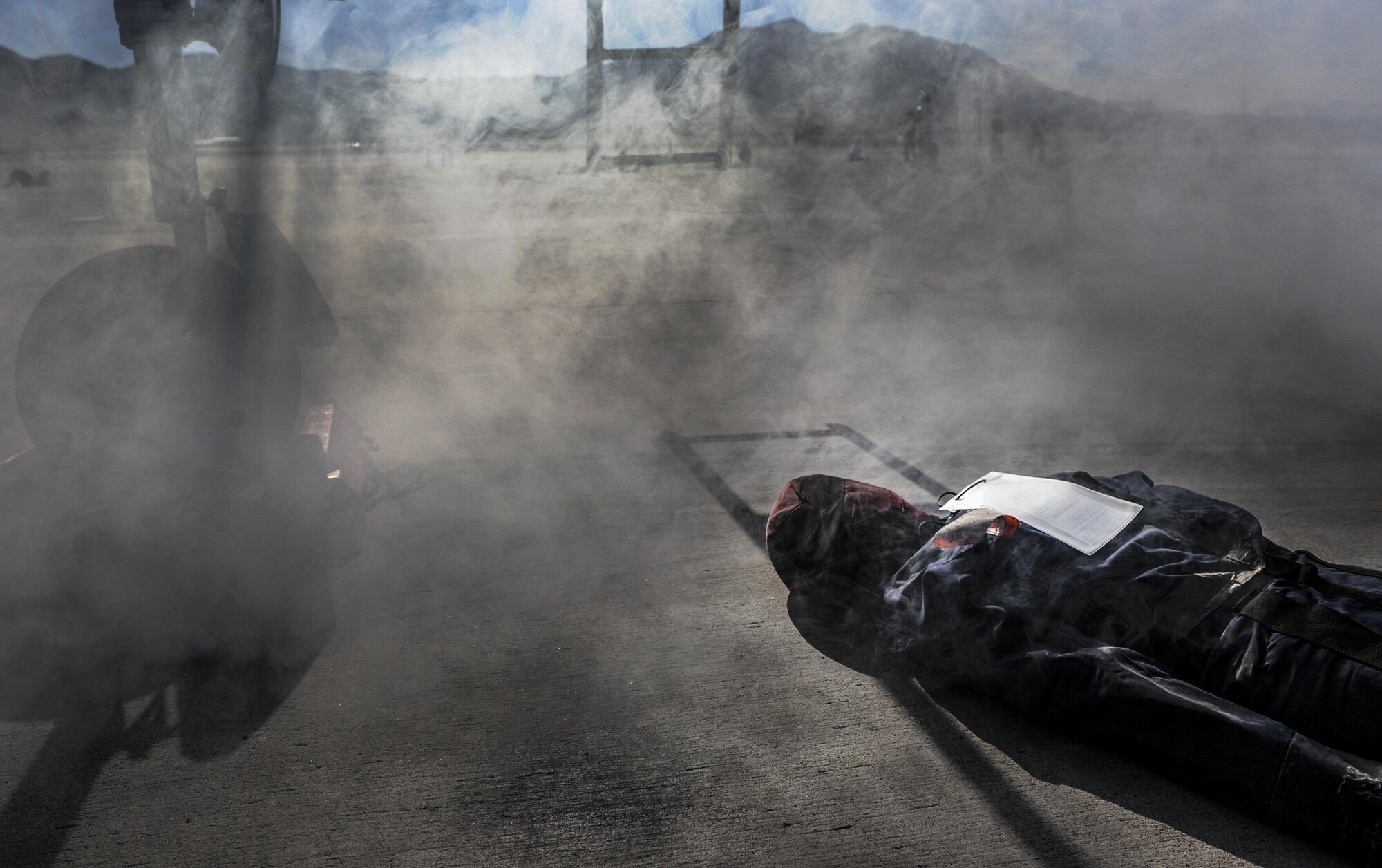 A simulated casualty lies underneath an F-15 Eagle during the Major Accident Recovery Exercise at Nellis Air Force Base, Nev., Oct. 13, 2016. Nellis AFB conducted the exercise to evaluate real-life response capabilities of emergency personnel for scenarios that could impact the base. (U.S. Air Force photo by Airman 1st Class Kevin Tanenbaum/Released)