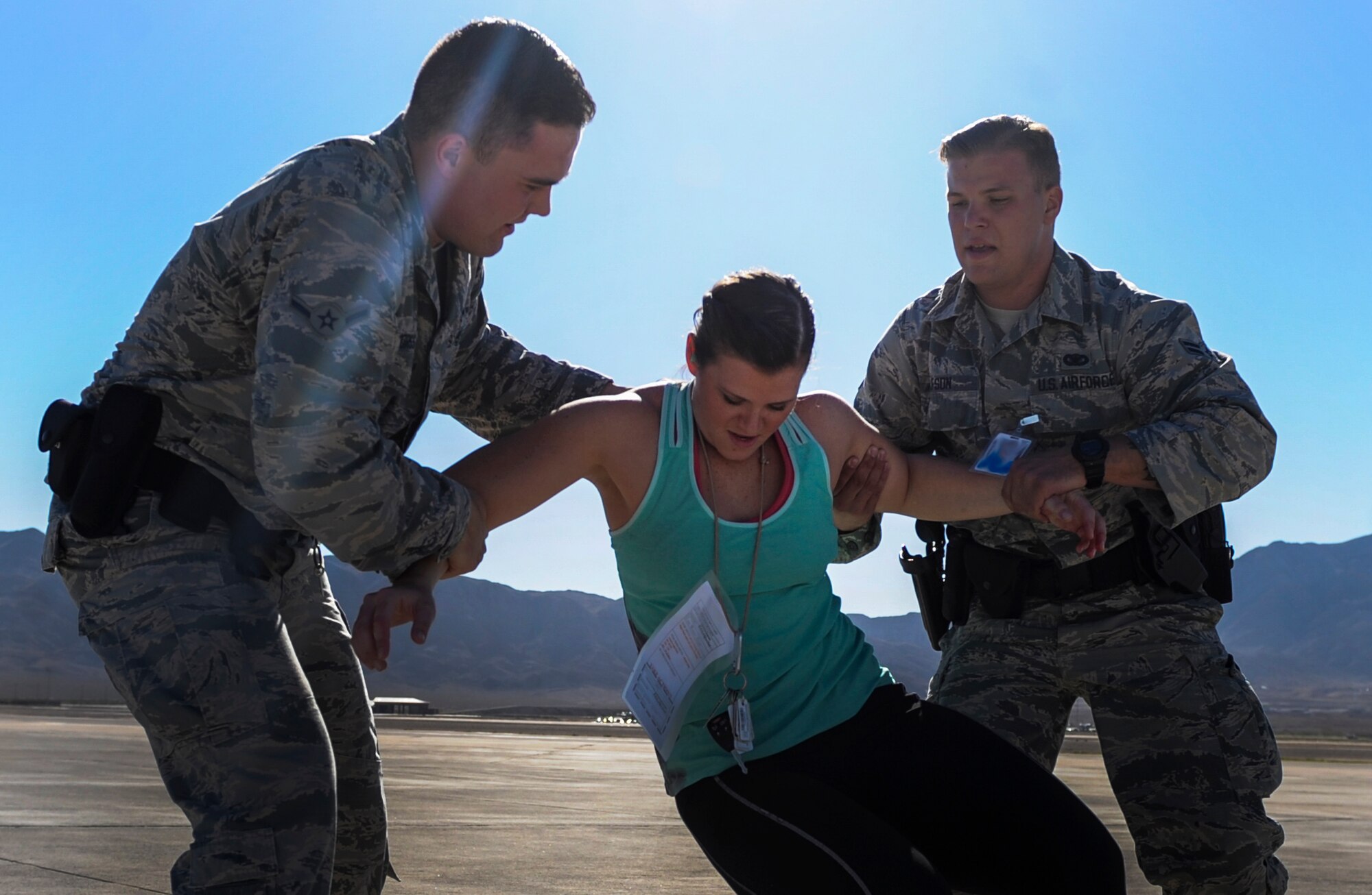 Airman Paul Morss and Airman 1st Class Wade Alfson, 99th Security Forces Squadron security forces members, help a simulated casualty to her feet during the Major Accident Recovery Exercise at Nellis Air Force Base, Nev., Oct. 13, 2016. The 99th SFS being the first on-scene of an emergency situation on base, has a wide range of responsibilities, including securing the scene and taking care of injured. (U.S. Air Force photo by Airman 1st Class Kevin Tanenbaum/Released)