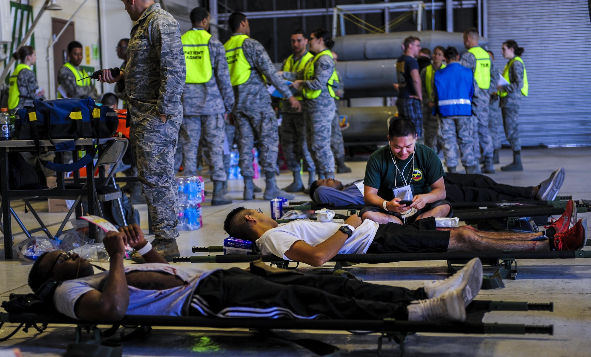 Simulated casualties lie on stretchers in a hangar during the Major Accident Recovery Exercise at Nellis Air Force Base, Nev., Oct. 13, 2016. The exercise took place to test the participating units ability to respond to an on base emergency. (U.S. Air Force photo by Airman 1st Class Kevin Tanenbaum/Released)