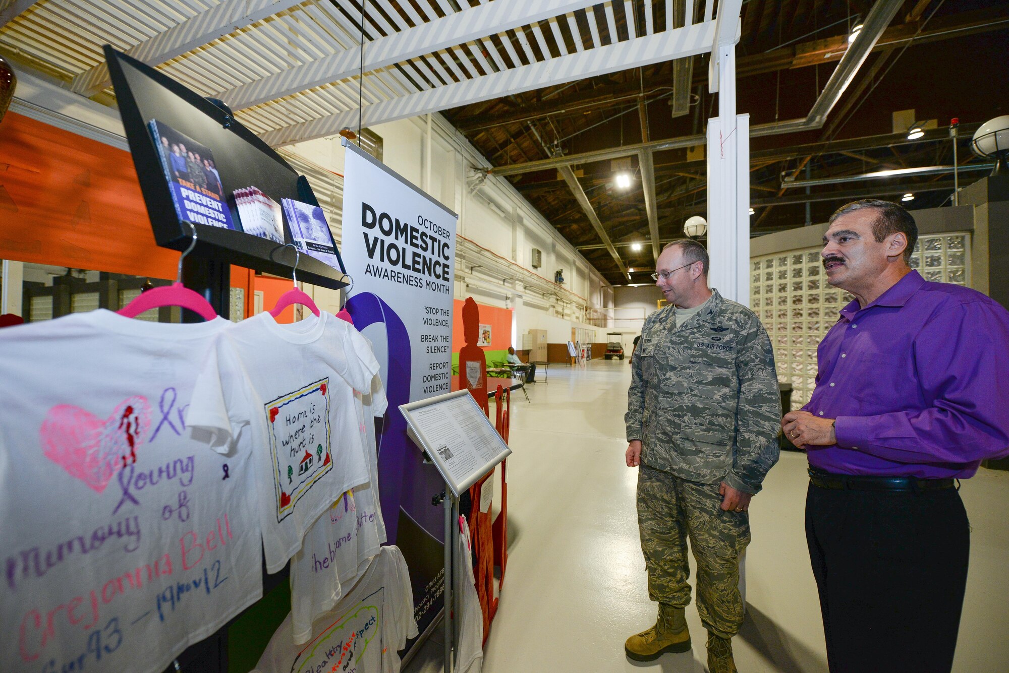 U.S. Air Force Col. David Berg (left), 55th Wing vice commander, talks with Kenneth Komyathy, family advocacy director, about the display set up to support Domestic Violence Awareness month in the Offutt Field House at Offutt Air Force Base, Neb., Oct. 18, 2016. According to the Department of Defense, domestic violence is an offense under the United States Code, the Uniform Code of Military Justice or state law that involves the use, attempted use, threat, use of force, violence against a person who is a current or former spouse, a person who shares a child with the abuser, a current or former intimate partner with whom the abuser shares a common domicile. (U.S. Air Force photo by Zachary Hada/Released)