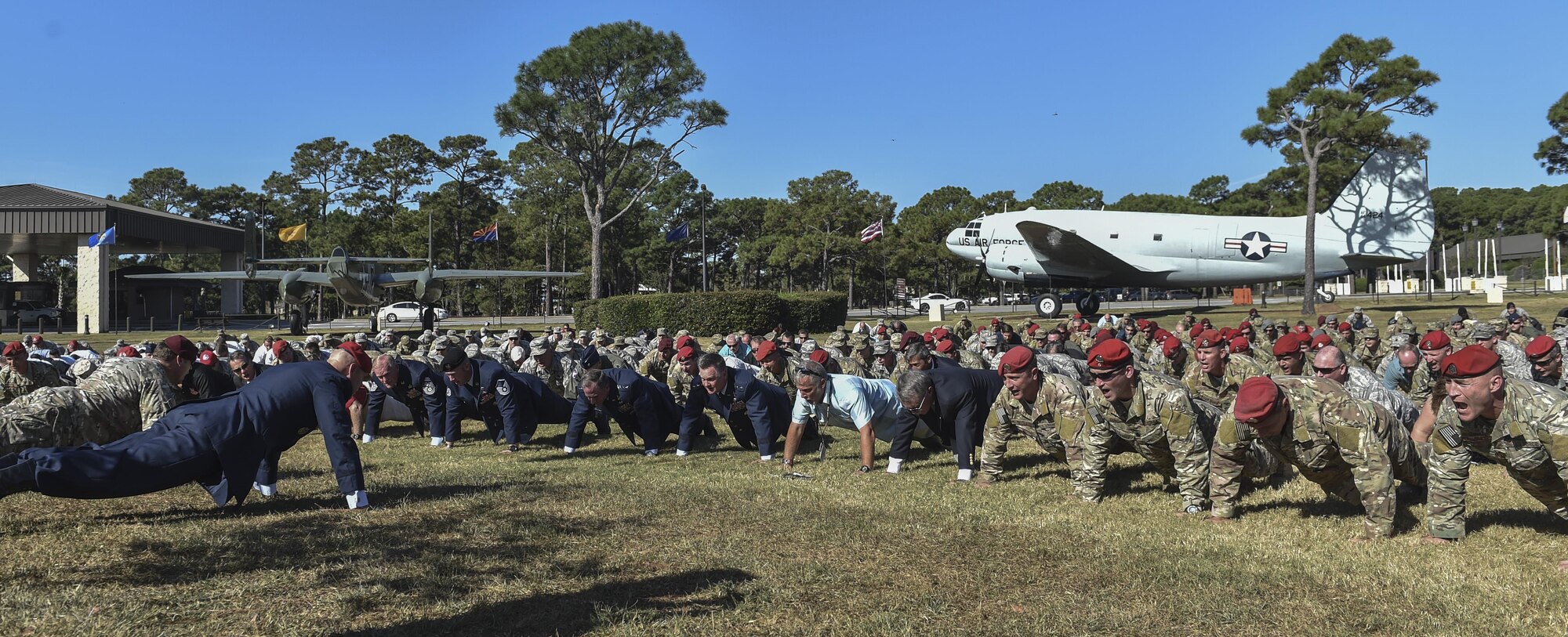 Hundreds of Airmen and families perform memorial pushups following the Special Tactics Memorial dedication ceremony at Hurlburt Field, Fla., Oct. 20, 2016. Flanking a seven-foot statue of an ST Airmen in operational gear will be two pedestals with the names of fallen ST Airmen --19 Airmen killed in action and eight in training-- a recognition of those who made the ultimate sacrifice. (U.S. Air Force photo by Senior Airman Ryan Conroy) 