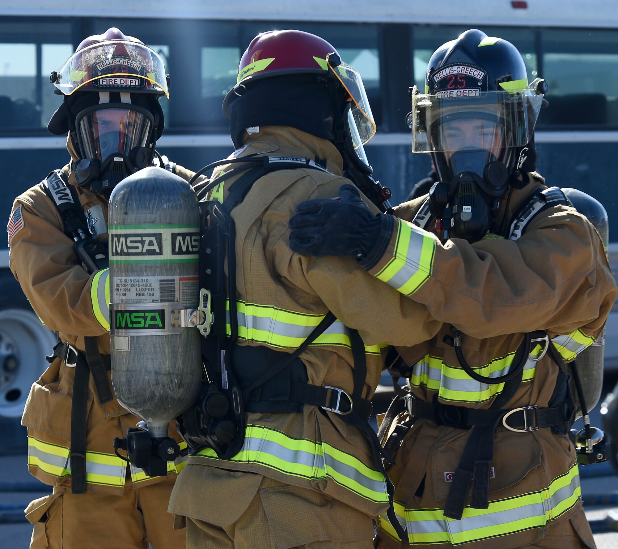 Firefighters assigned to the 99th Civil Engineer Squadron Fire Protection Flight, celebrate after completing a live burn exercise Sept. 23, 2016, at Creech Air Force Base, Nev. Firefighters are required to complete a live burn exercise semi-annually to keep current on their training. (U.S. Air Force photo by Airman 1st Class James Thompson)
