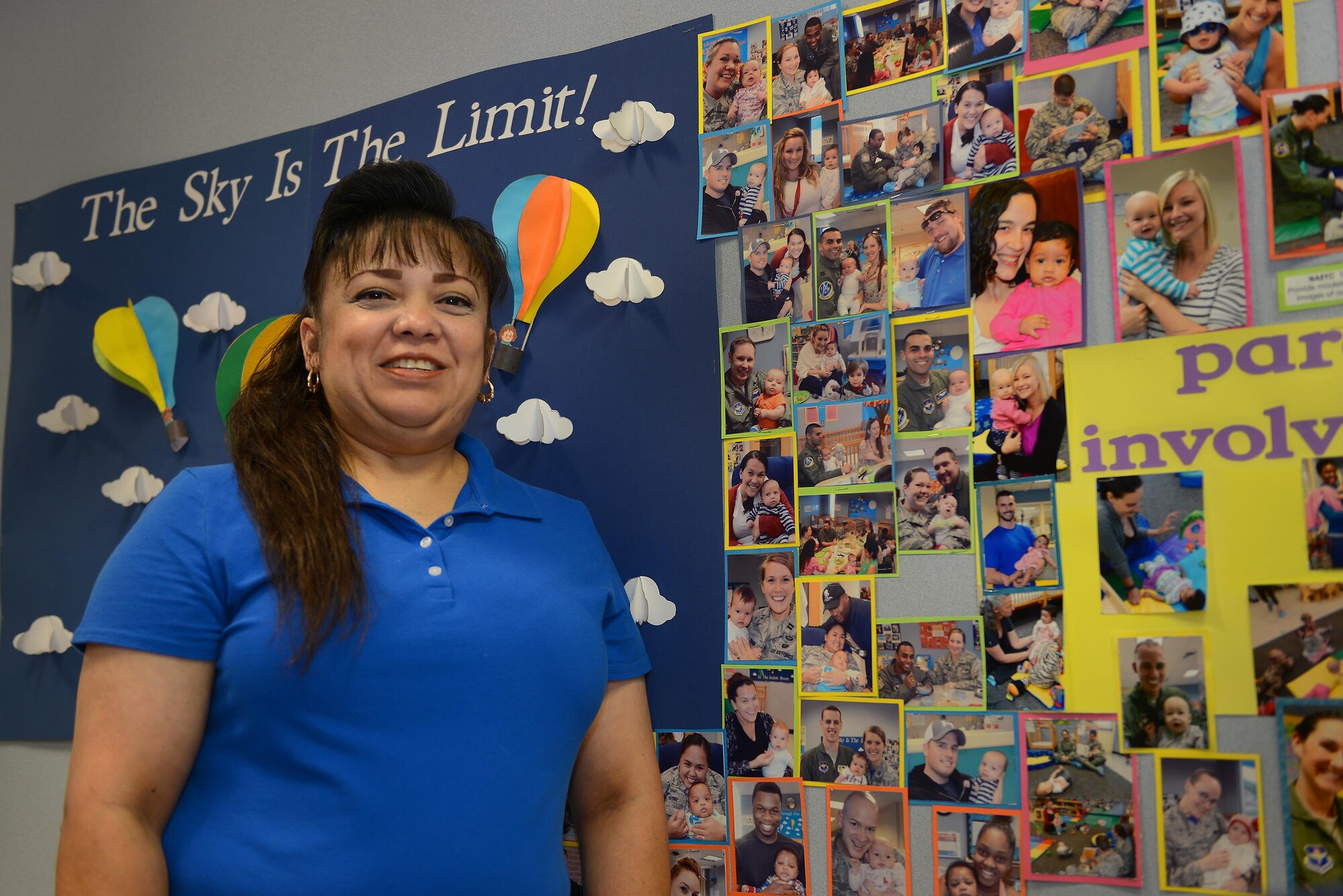 Bertha Murrell, 47th Force Support Squadron child and youth program technician, stands in front of her wall of families she has bonded and helped with over the years, Laughlin Air Force Base, Texas, October 20, 2016. Murrell finds immense joy in her job, and loves helping take care of, nurture and develop Laughlin’s children. (U.S. Air Force photo/Airman 1st Class Benjamin N. Valmoja)