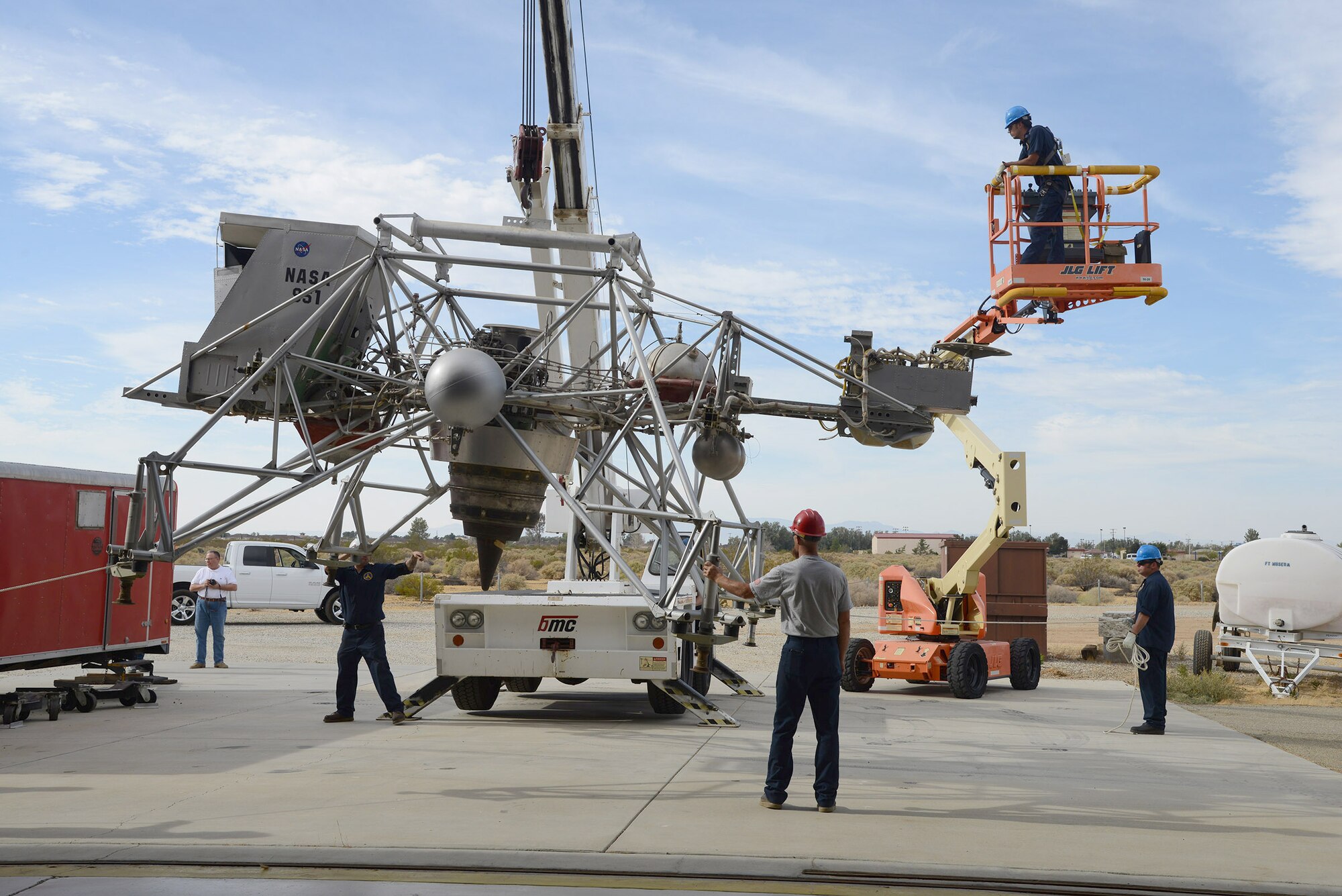Workers lower NASA’s Lunar Landing Research Vehicle to the concrete behind the Air Force Flight Test Museum Oct. 13. The LLRV and the Space Shuttle Crew Transport Vehicle were both donated by NASA’s Armstrong Flight Research Center. (U.S. Air Force photo by Christopher Ball)